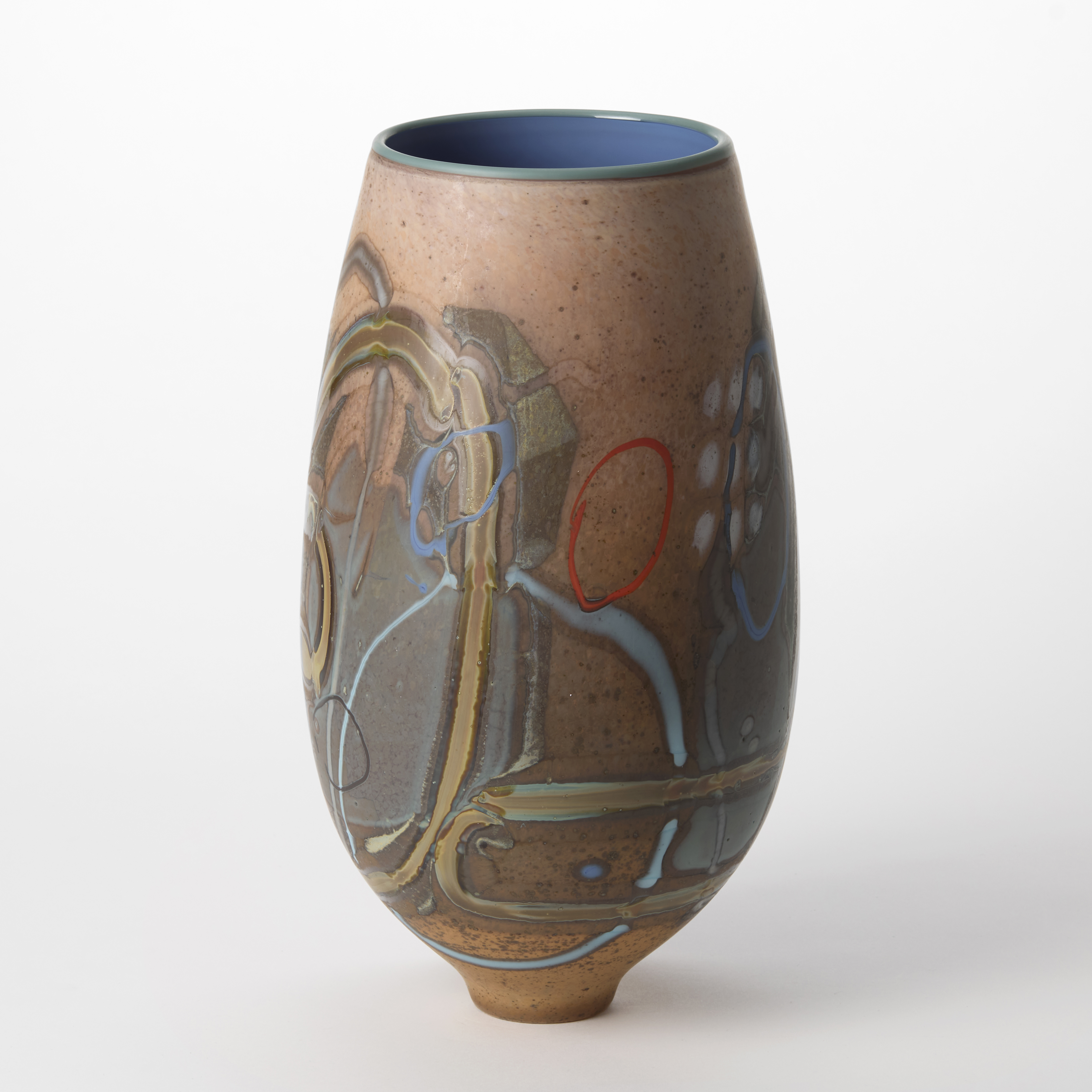 light chocolate coloured teardrop shaped vase with abstract decoration on the surface consisting of lines and dots in ochre red light blue and white with a shiny mid blue interior hand blown from glass