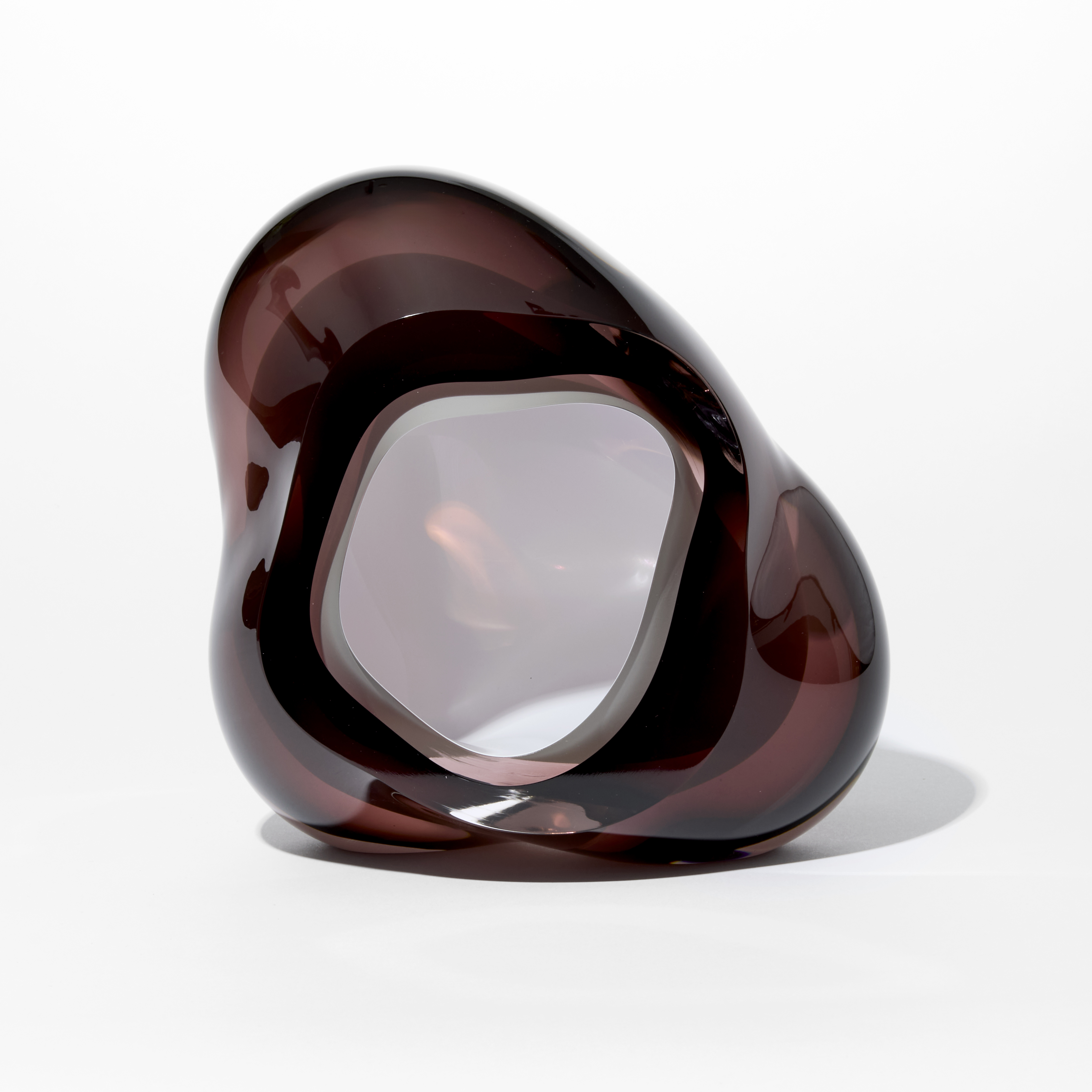 tall glossy transparent dark brown organic rock shaped form with opaque white lined interior hole hand made from glass