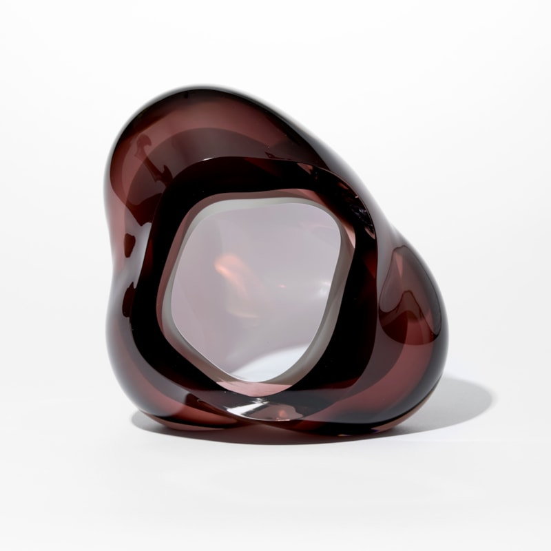 tall glossy transparent dark brown organic rock shaped form with opaque white lined interior hole hand made from glass