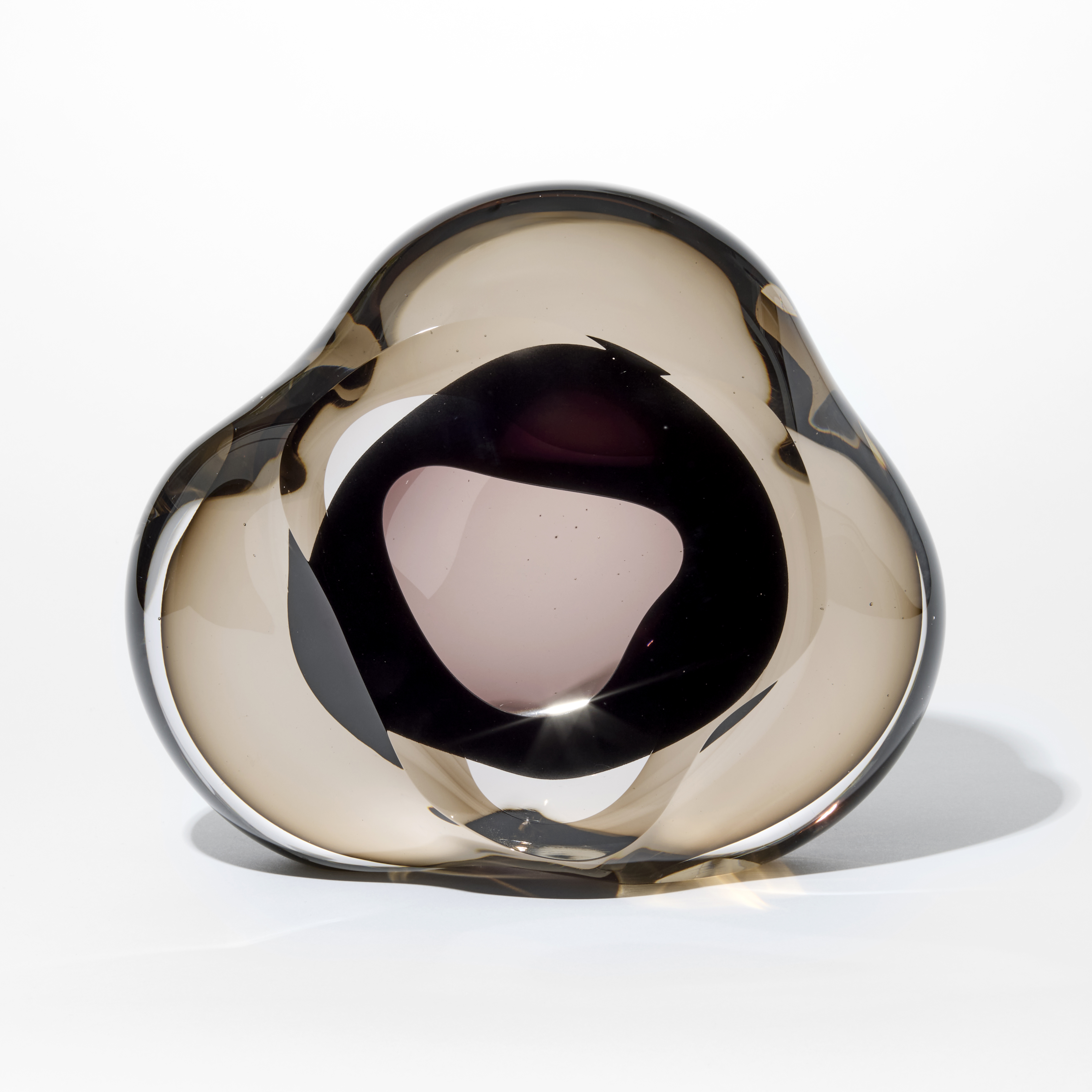 transparent bronze soft triangular shaped pebble with an interior soft mass in rick dark brown and a front opening into the interior hand made from glass