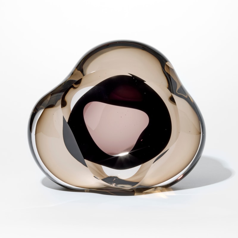 transparent bronze soft triangular shaped pebble with an interior soft mass in rick dark brown and a front opening into the interior hand made from glass