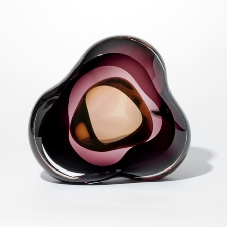 glossy transparent aubergine and brown fluid pebble with three rounded corners and interior rounded cavity hand made from glass