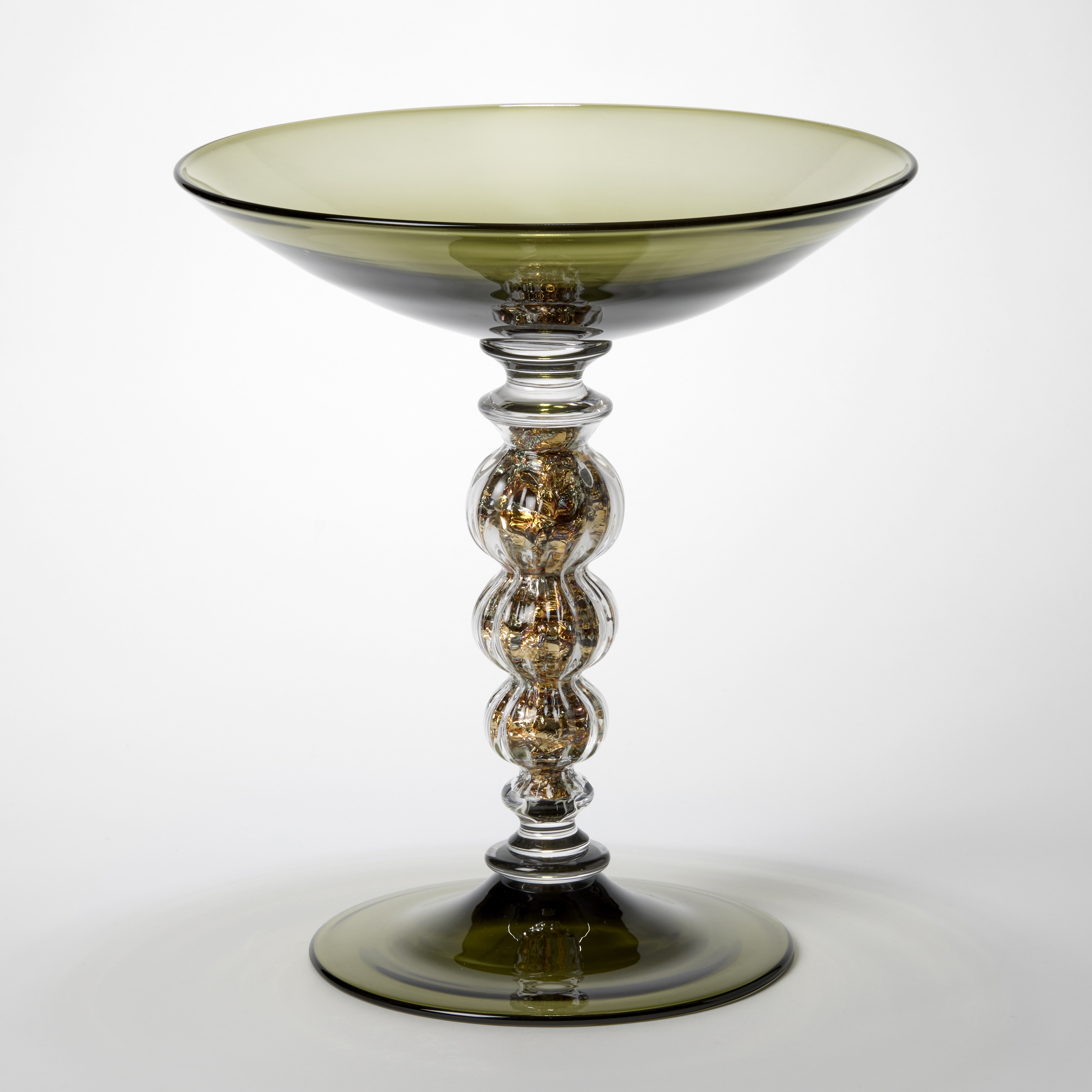transparent moss khaki green centrepiece with ridged undulating stem holding silver and brass scrunched leaf hand made from glass using venetian techniques