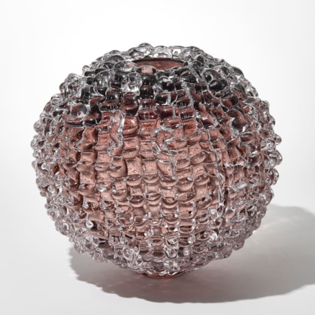 transparent round smokey aubergine tinted vase with small top opening and outer surface covered in soft merging linear lines with raised ridges hand made from blown and sculpted glass