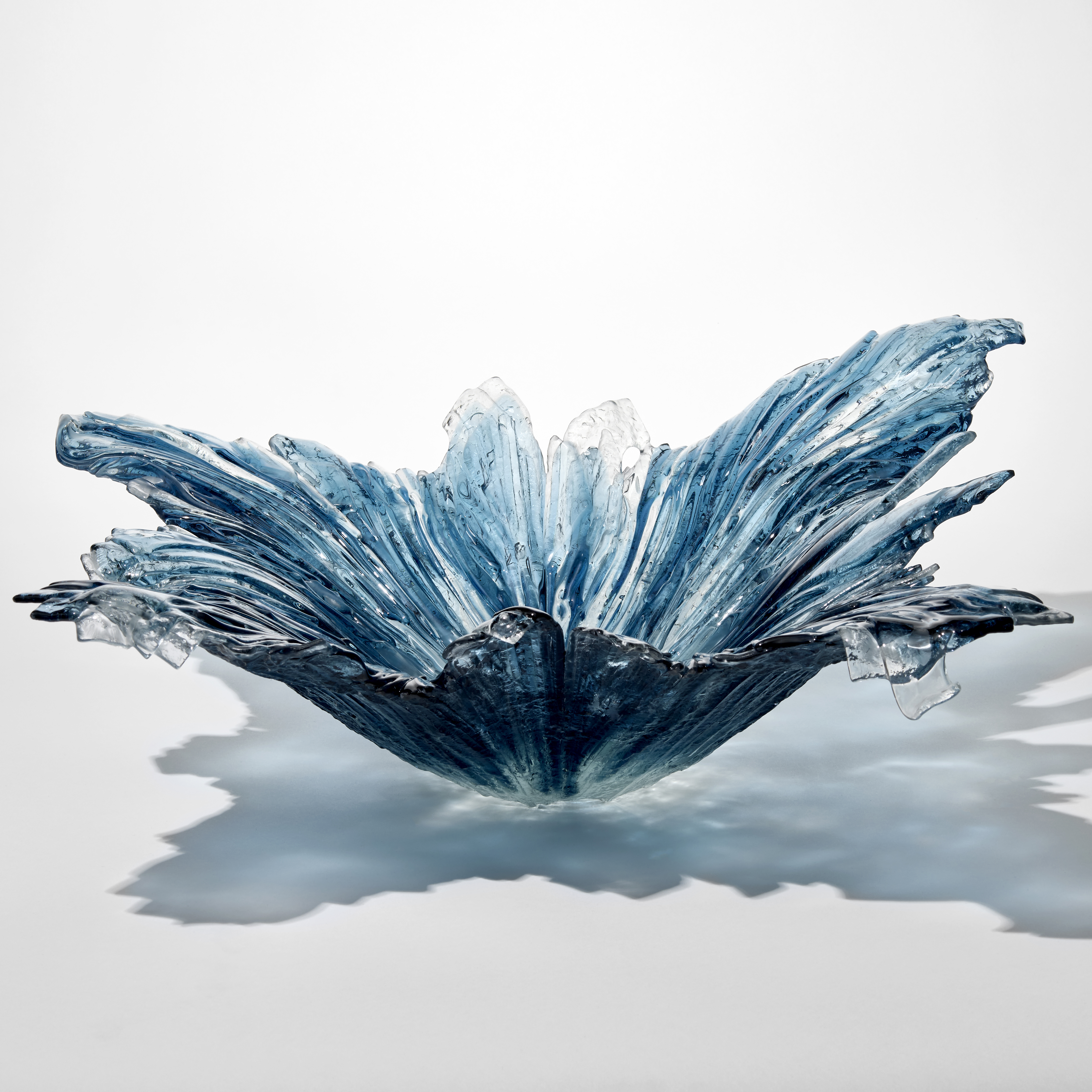 large semi transparent centrepiece in blue aqua and clear with the appearance of a large diving splash hand made from glass