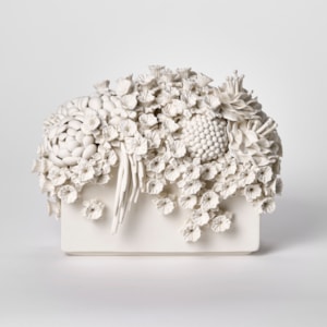 white low rectangular block with a multitude of different flowers and blooms covering and spilling over the top and edges hand made from porcelain