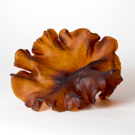 opaque dark amber organic form resembling a piece of round frilly seaweed hand made from cast glass with a ridged textured cut into the under surface