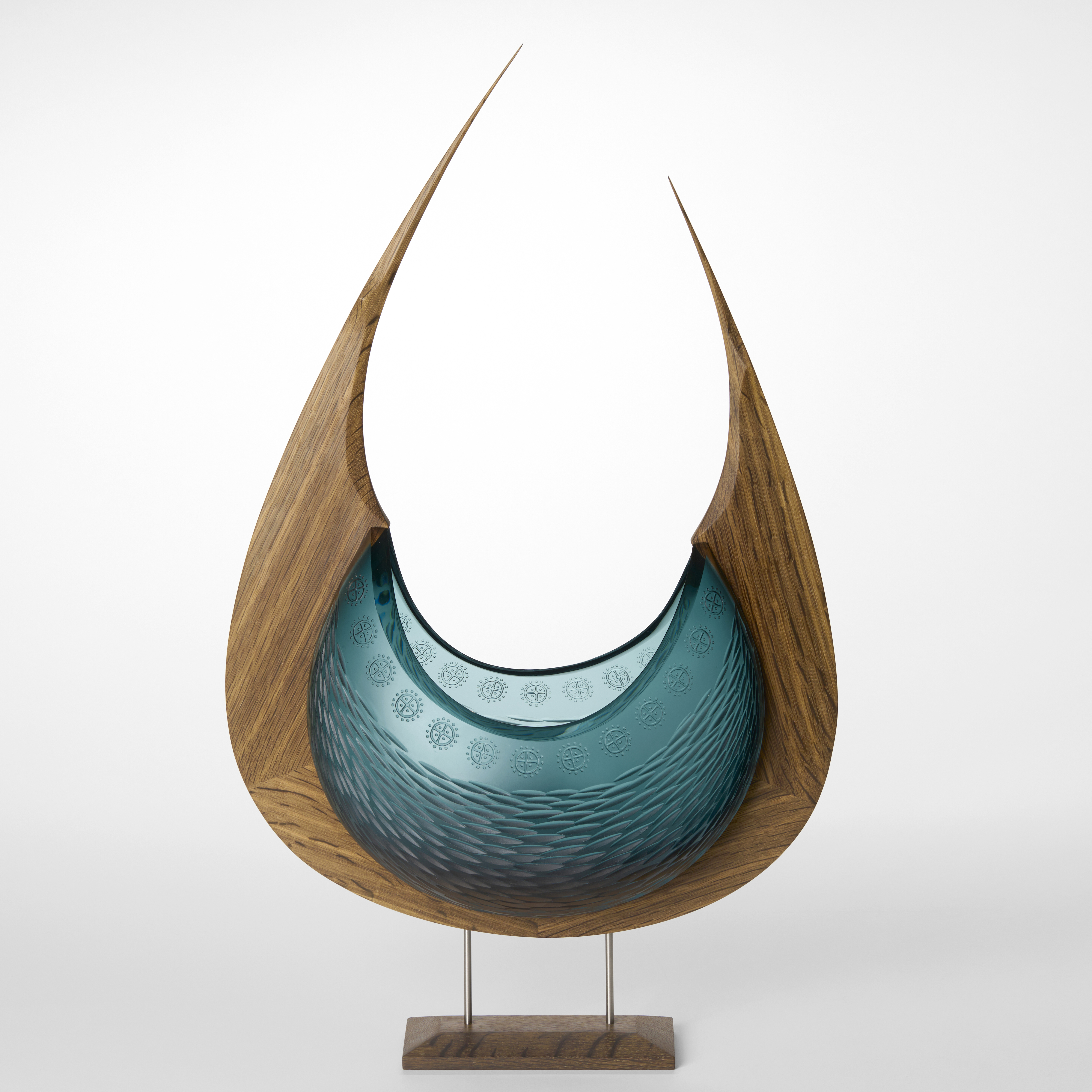 tall arced stylised viking ship with wooden keel lifting to pointed bow and stern and organically textured incised glass hull hand made from oak and blown glass