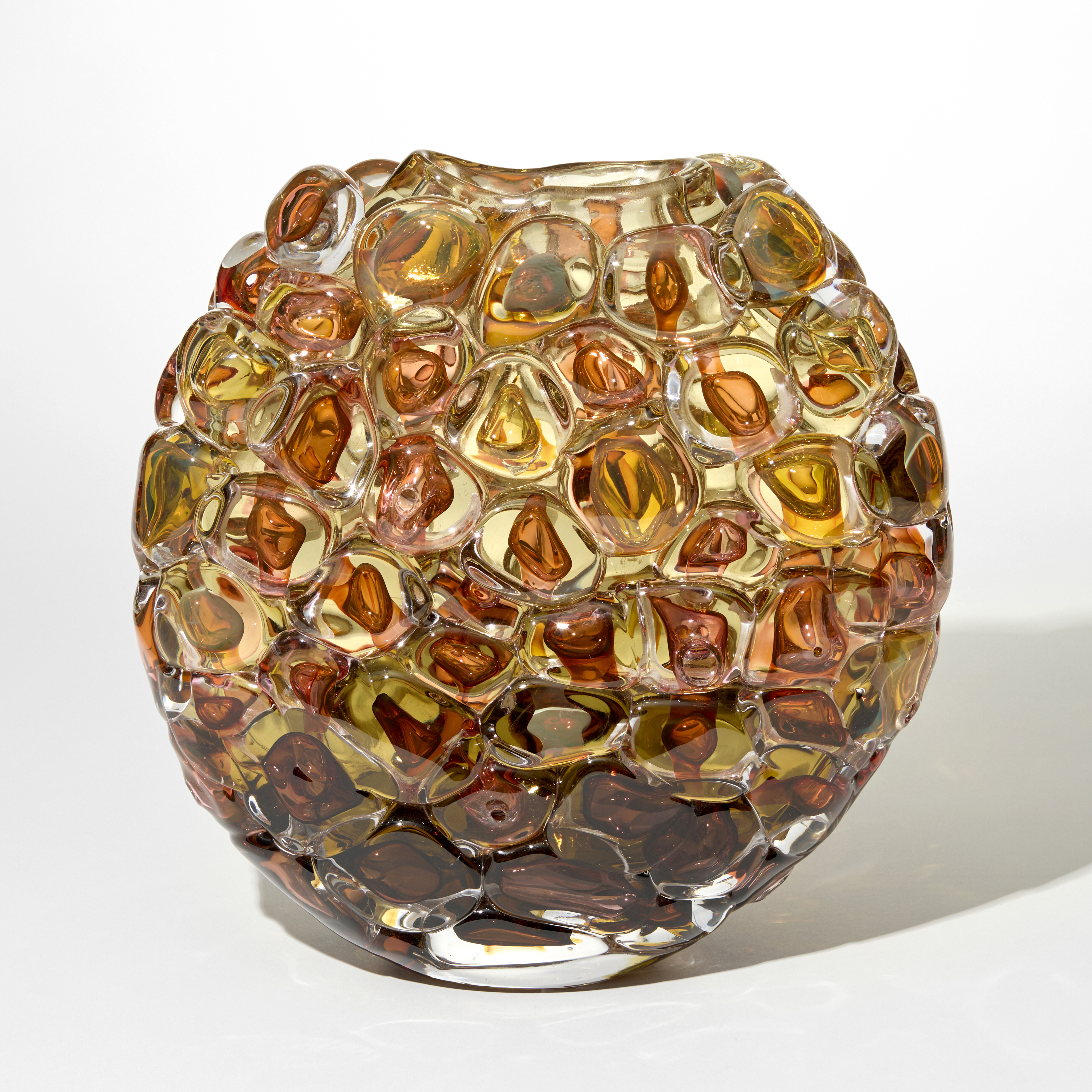oval profiled transparent vase with the outer surface covered in large oversized squashed bubbles in amber and gold hand blown from glass