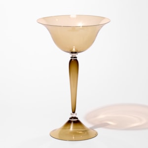 tall classical centrepiece in transparent ochre bronze brown with a flared wide round foot and an elegant thin long stem with a flared generous round bowl on the top hand blown from glass using venetian techniques