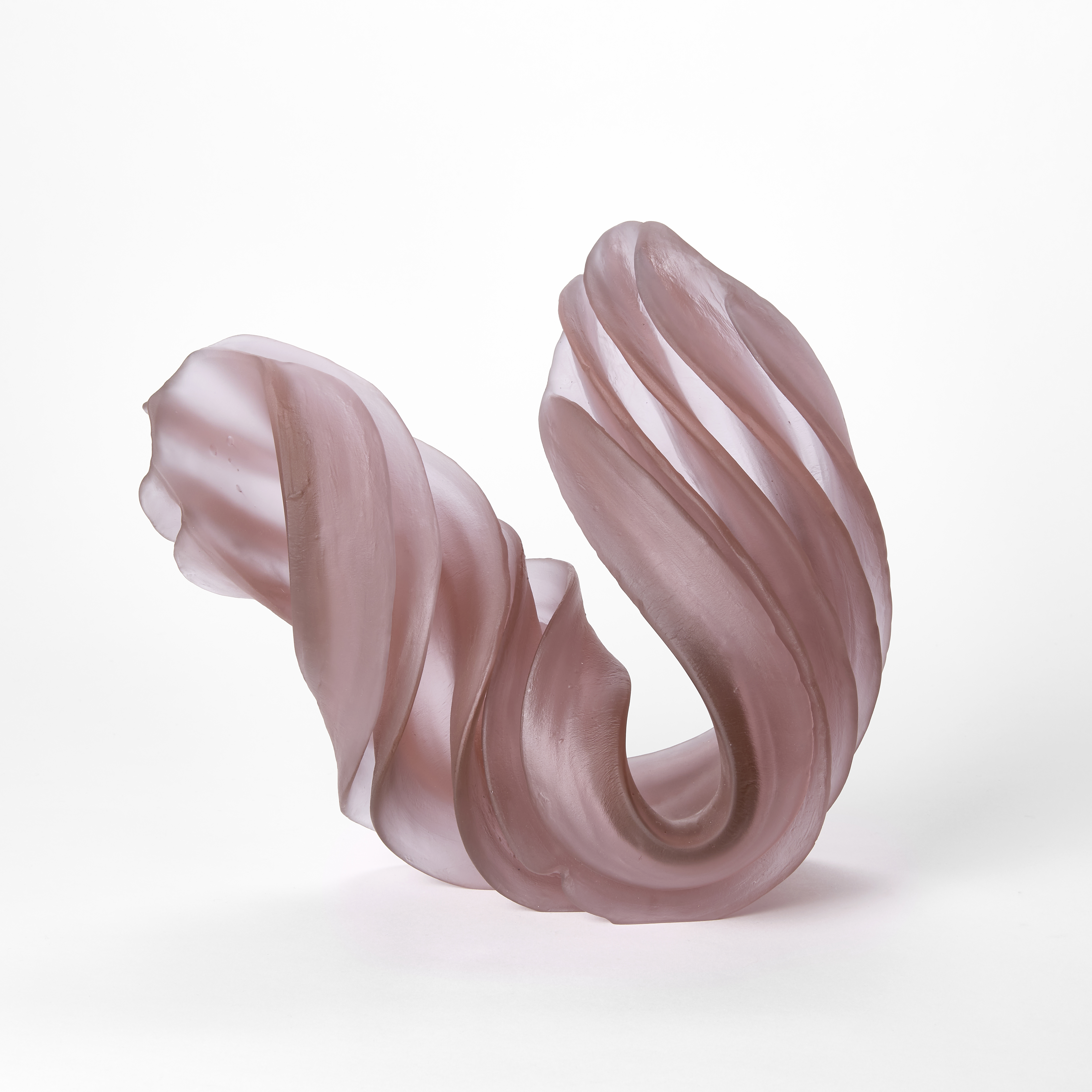ridged u shaped looped sculpture in semi transparent soft pink with one side curled round and pulling away the other gently curved and reaching upwards hand made from cast glass