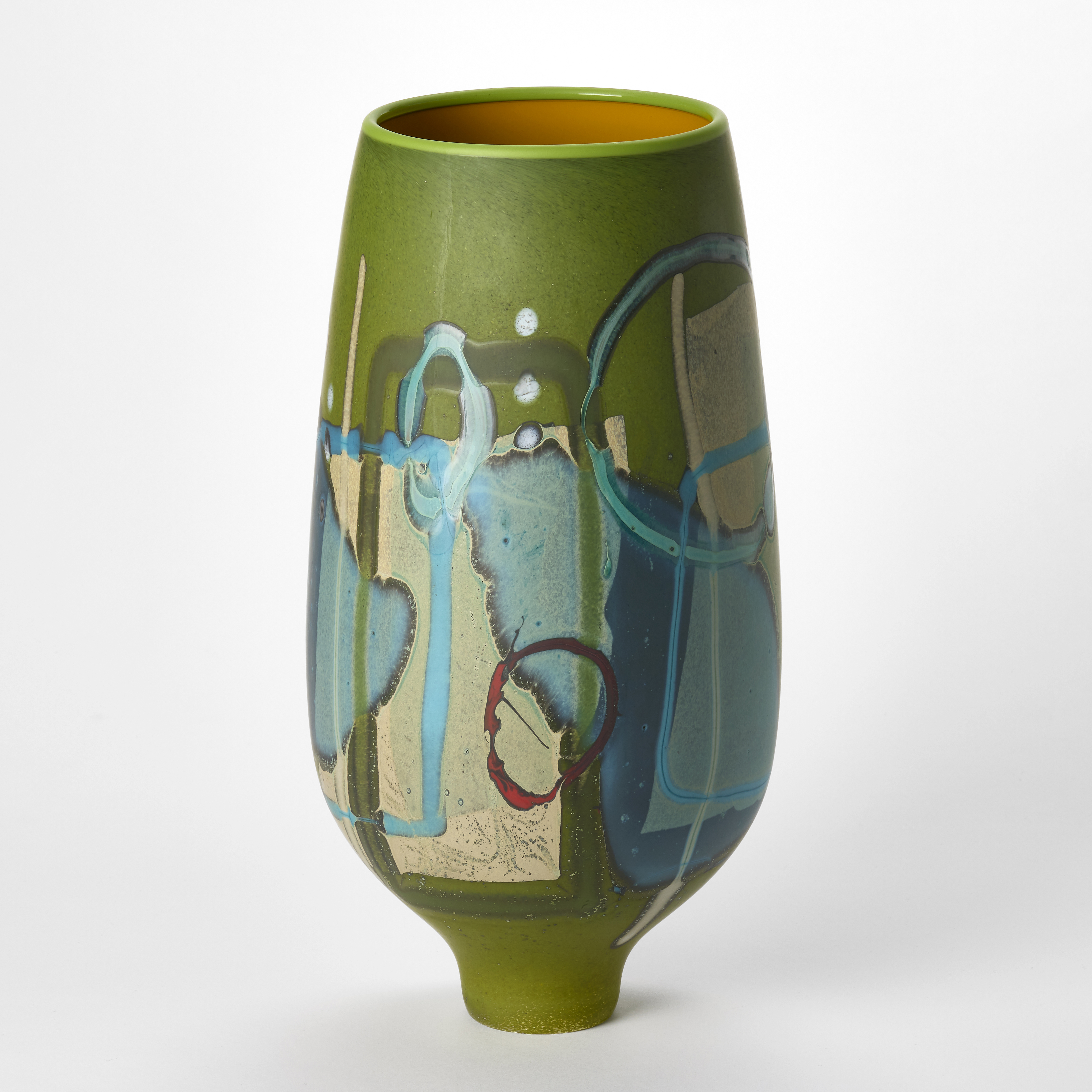 tall opaque rich green vase with a matt surface covered in abstract patterns in white teal turquoise red and soft nude pink with an elegant tapering foot hand blown from glass