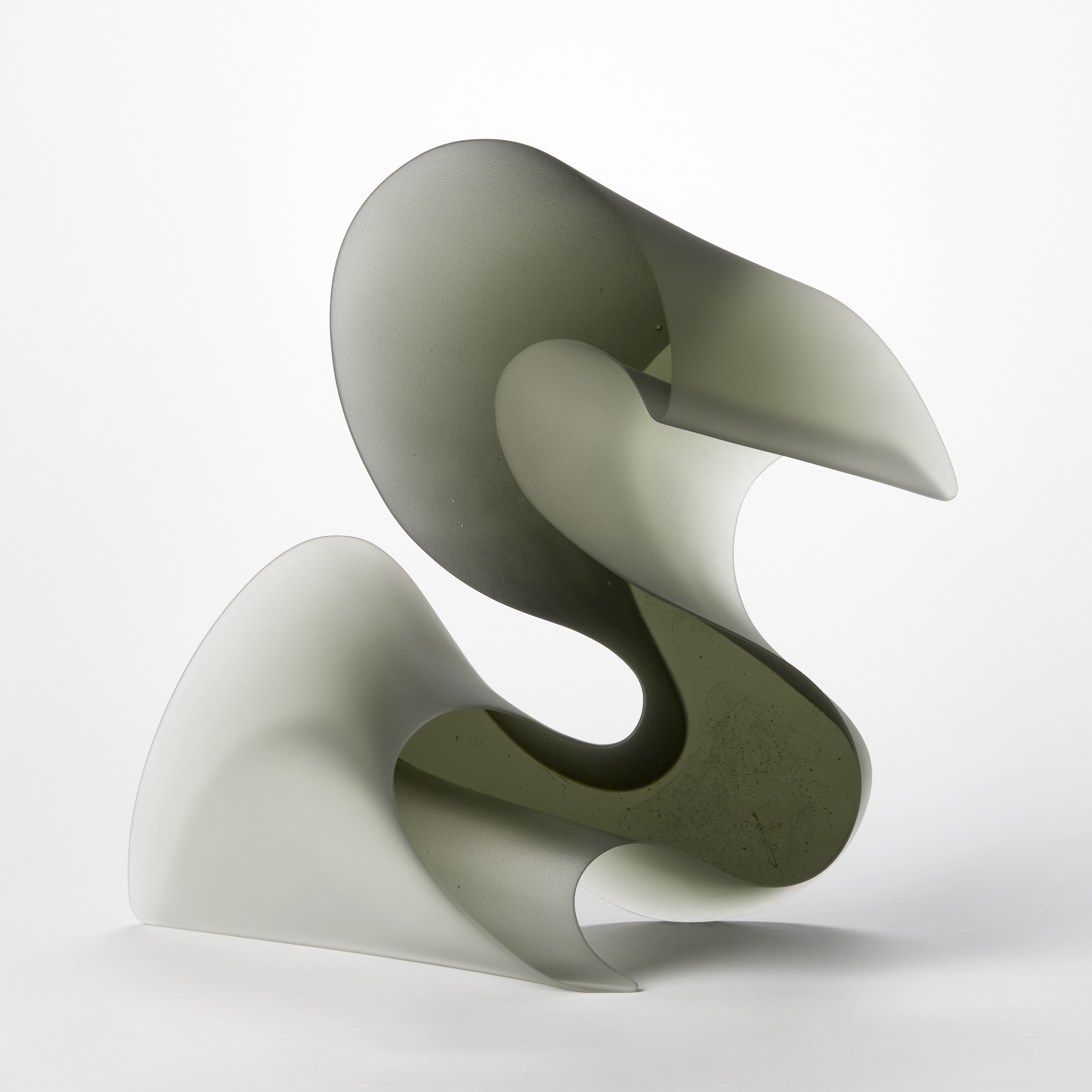 chunky transparent grey standing form that resembles flamboyant script and calligraphy and in particular the letter s hand made from cast glass