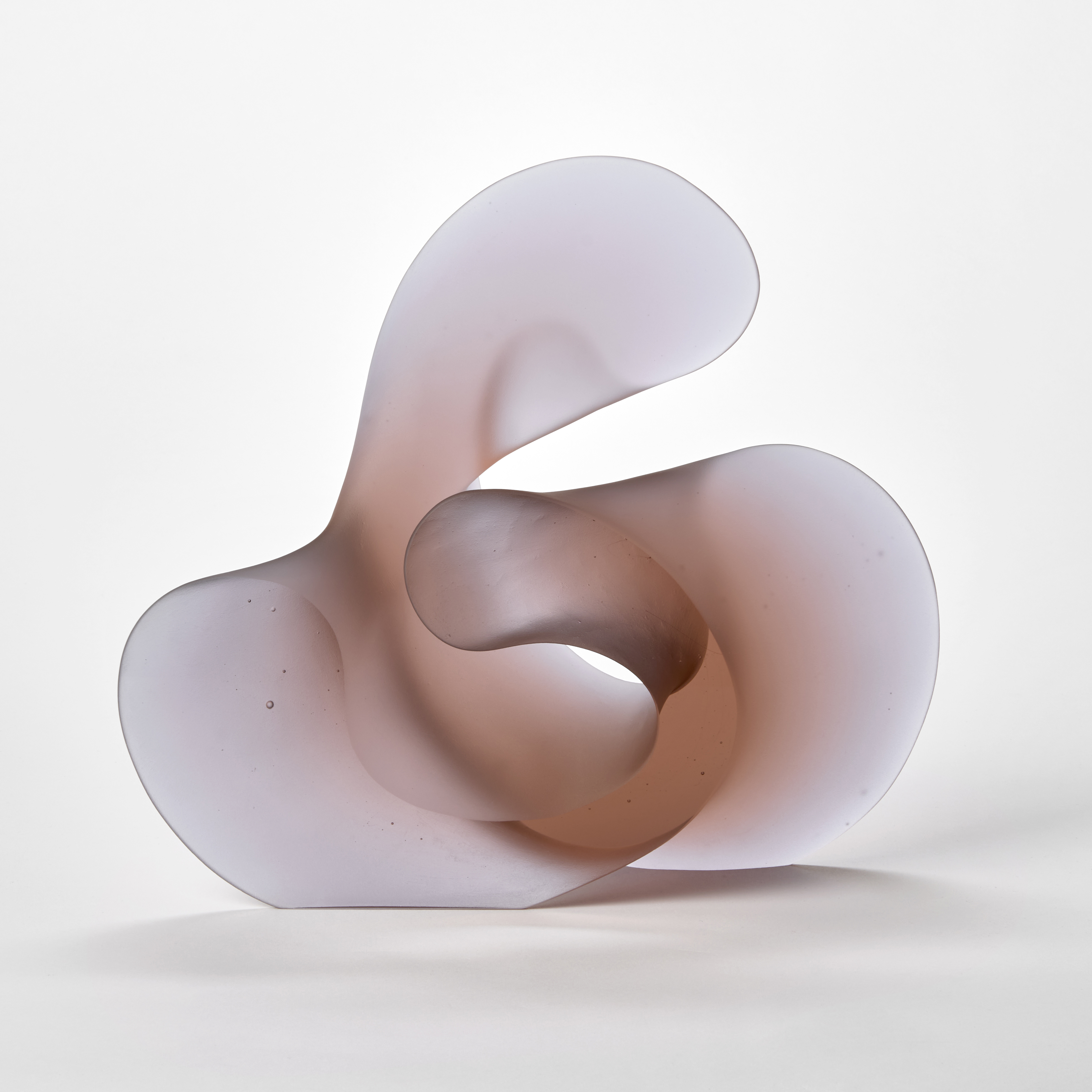 chunky curled semi transparent soft pink and pale lilac standing curled form with the appearance of calligraphy hand made from cast glass