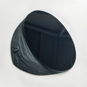 black matt and shiny wall mounted abstract artwork with upper oval reflective section and lower matt organically textured area hand made from glass