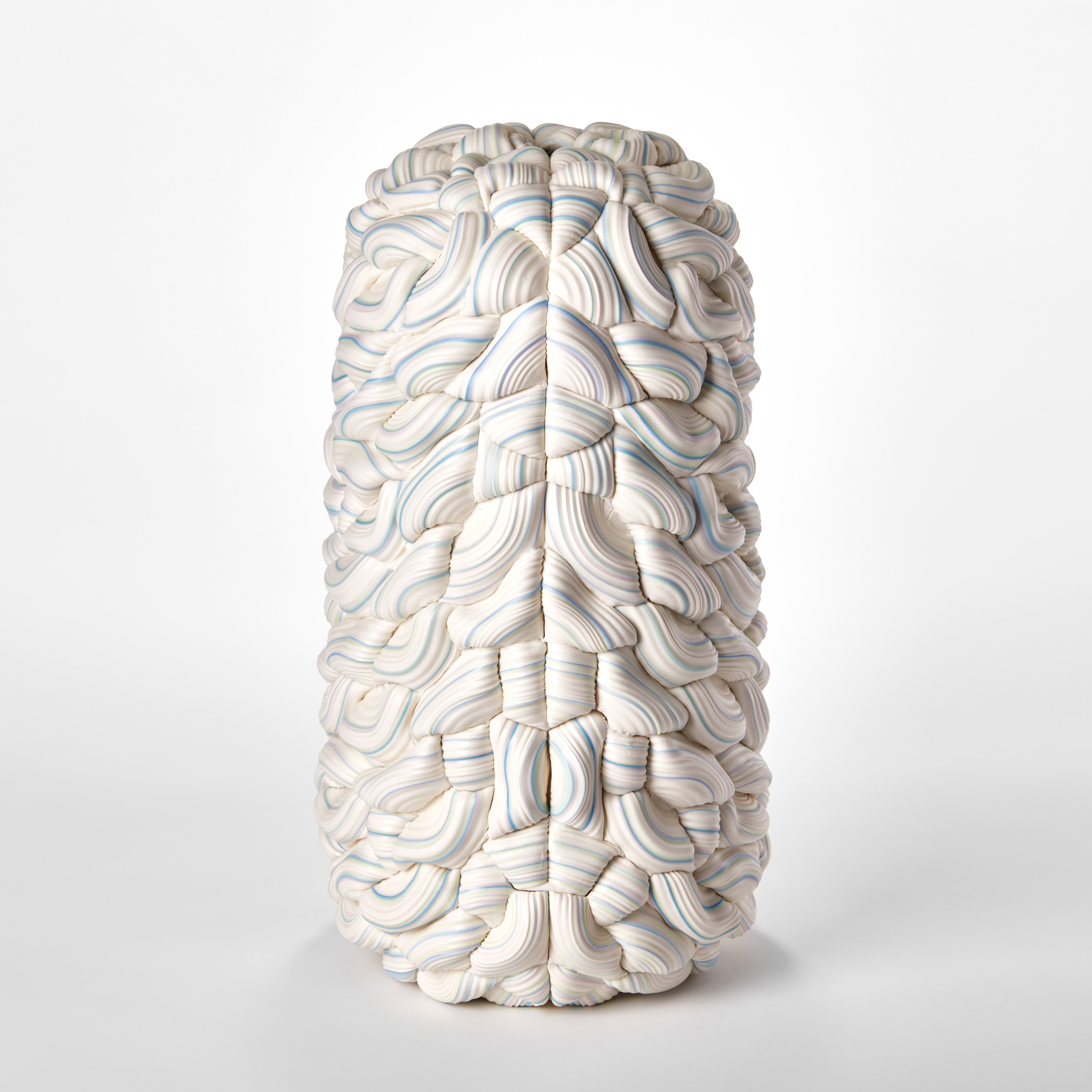 stacked sculpture consisting of interwoven ridged rings of white with bands of colours in turquoise yellow and pink with central seam and in two halves mirroring each other