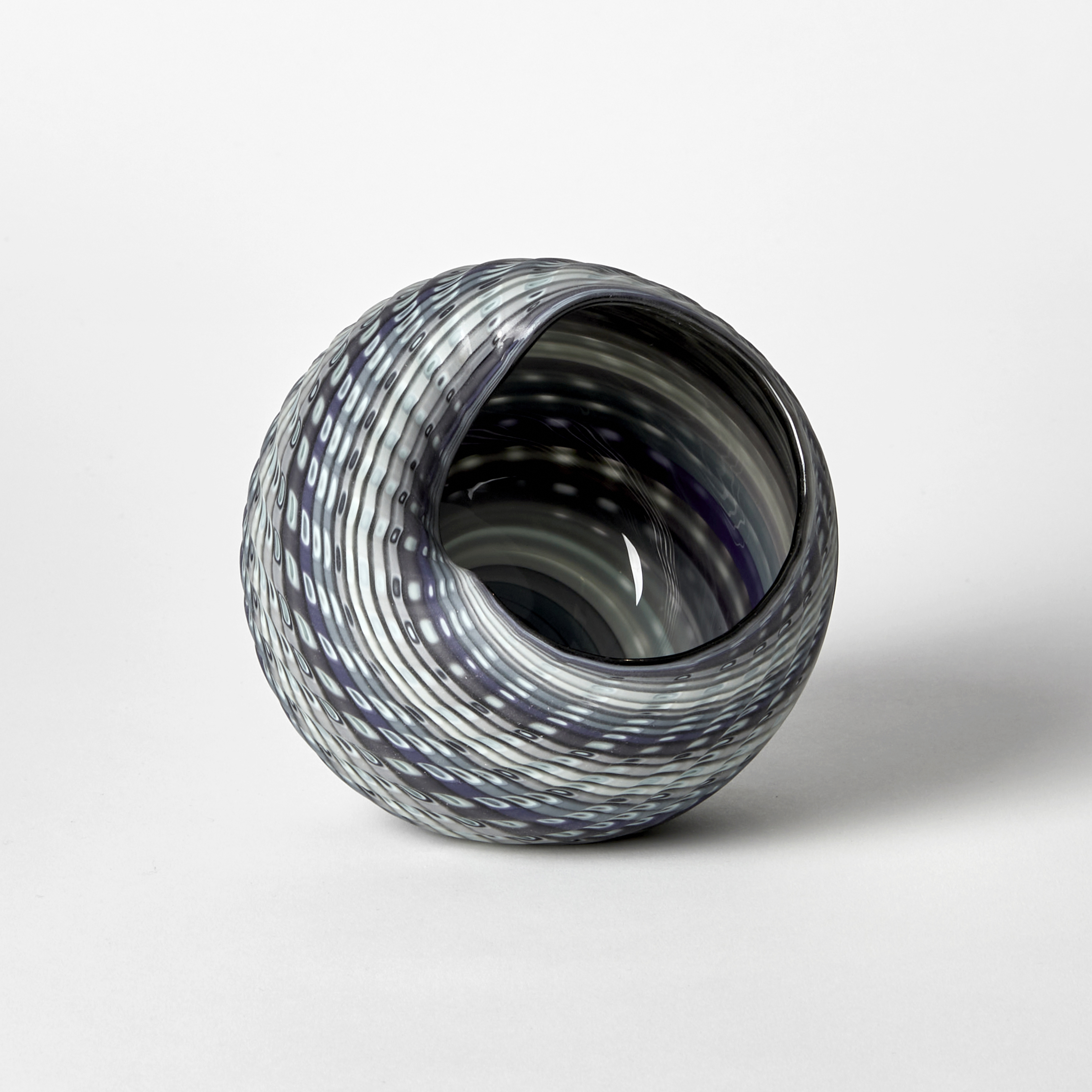 round shell like vessel with matt incised and textured outside and shiny inside with bands of colour in blue jade alabaster and blue hand made from glass