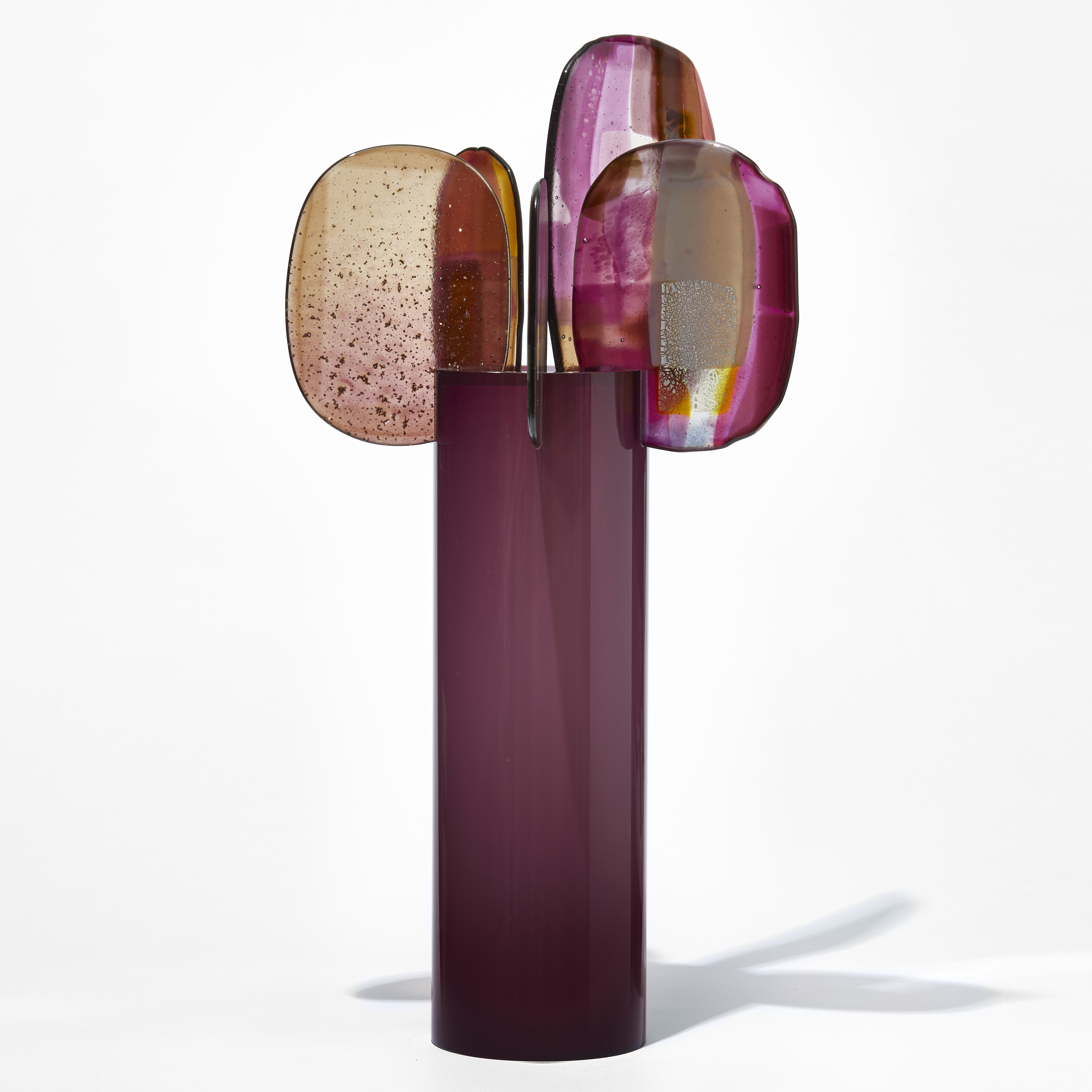 tall glossy opaque magenta purple cylinder with five rounded glass finials perched on the top rim with abstract patterns in pink red aubergine gold and yellow hand made from blown and fused glass