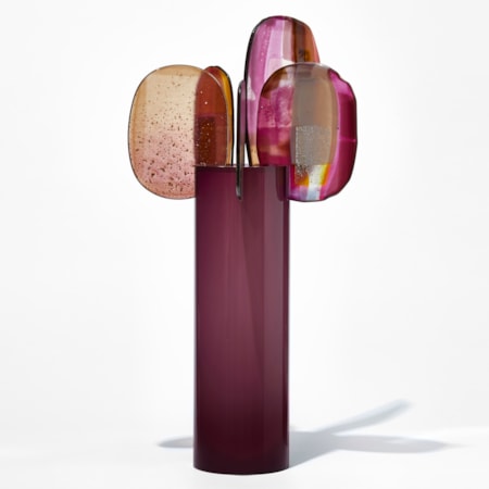 tall glossy opaque magenta purple cylinder with five rounded glass finials perched on the top rim with abstract patterns in pink red aubergine gold and yellow hand made from blown and fused glass