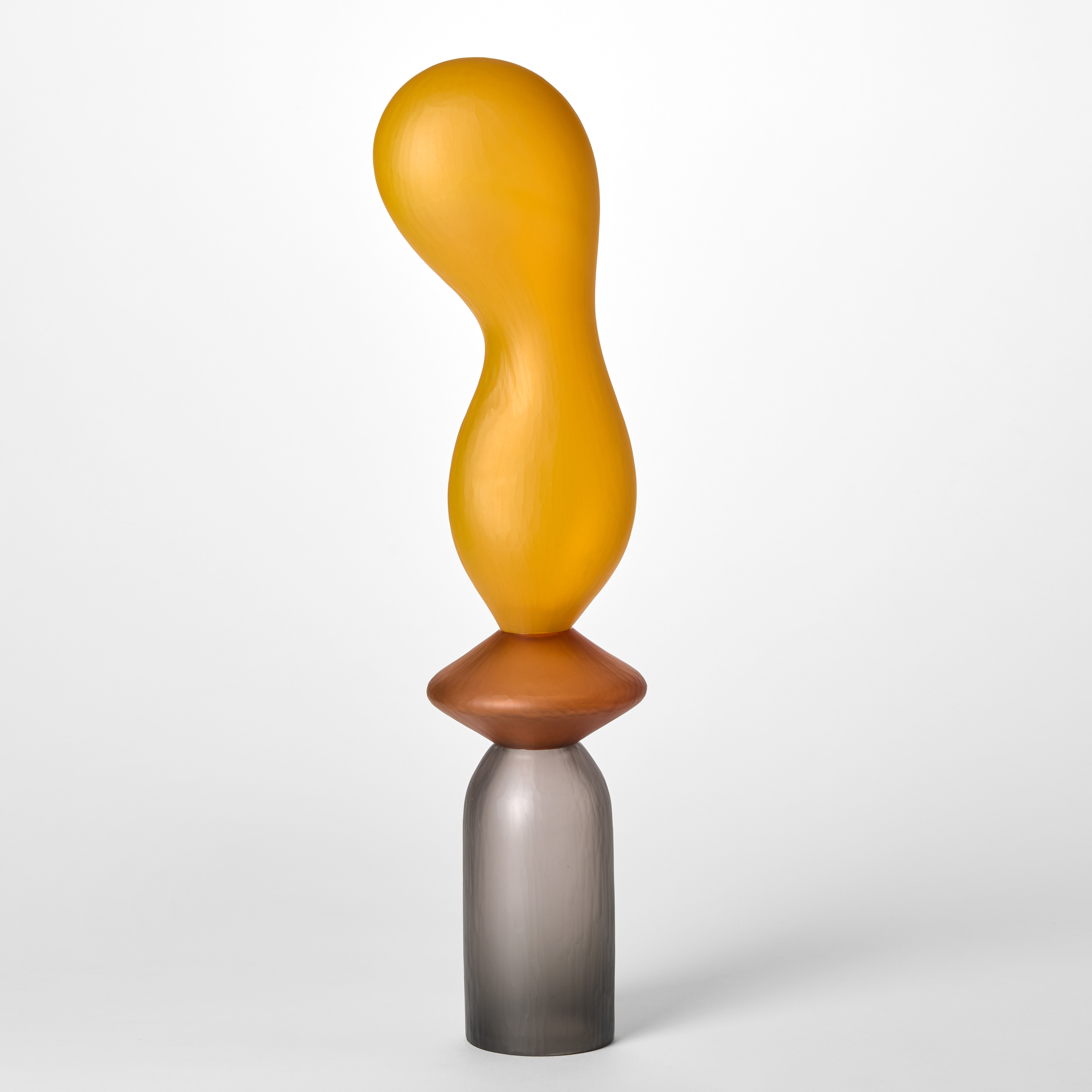 tall abstract geometric sculpture created from three stacked shapes in grey sienna and orange hand made from blown glass with a textured surface