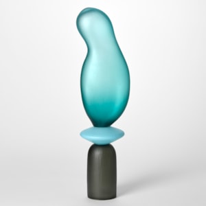 tall opaque sculpture consisting of three stacked shapes an upside down grey cup a turquoise disc and an bulbous balloon form in teal hand blown from glass with a textured surface