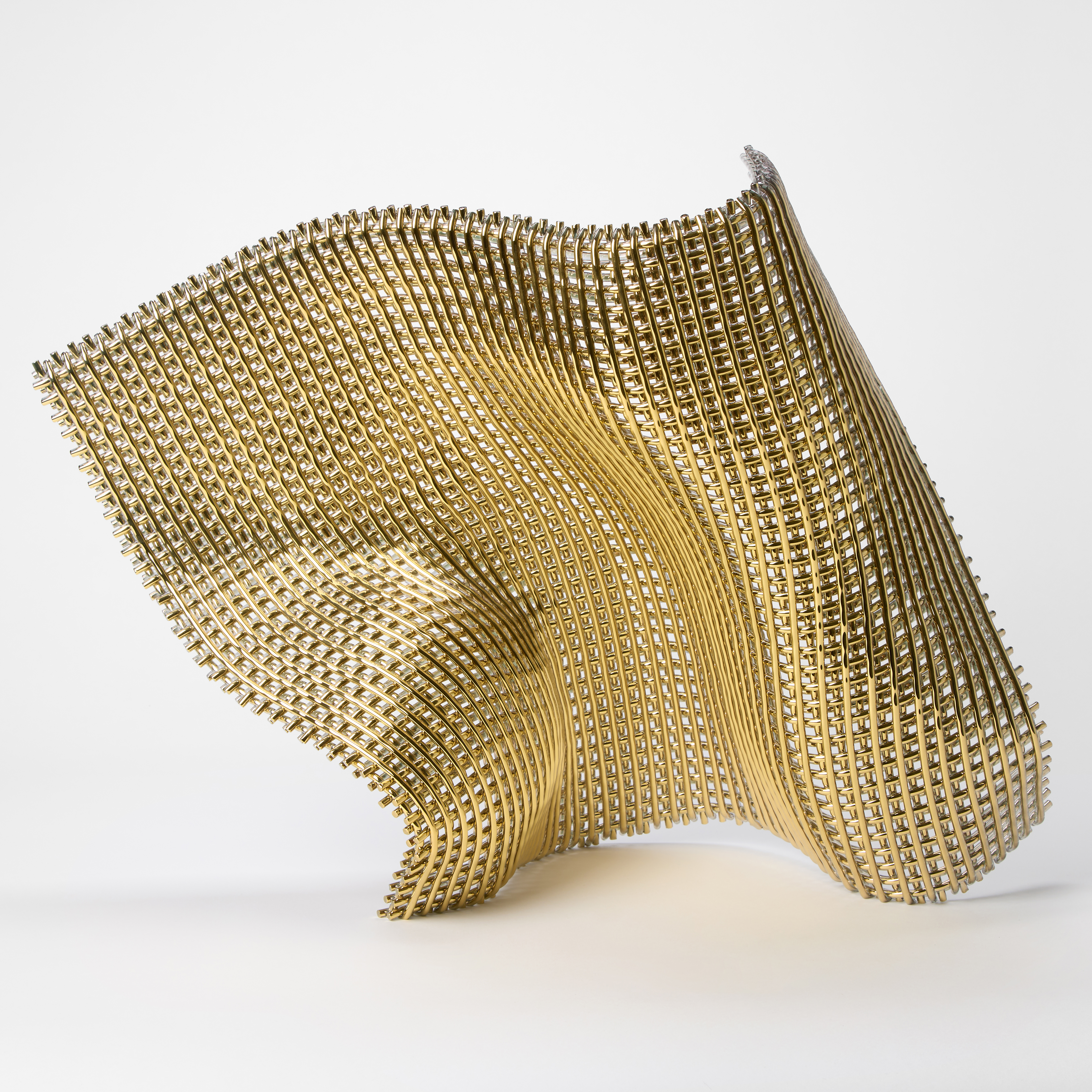 shimmering golden standing square woven collapsing form with folds and bends as if about the fall flat on the ground hand made from glass and twenty four carat gold