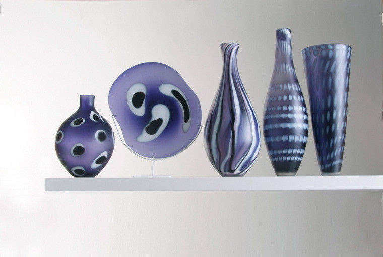 five purple hand blown glass vases in different shapes and patterns