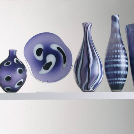 five purple hand blown glass vases in different shapes and patterns