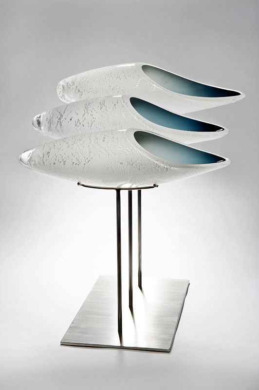 three fish shaped white glass sculptures on metal base