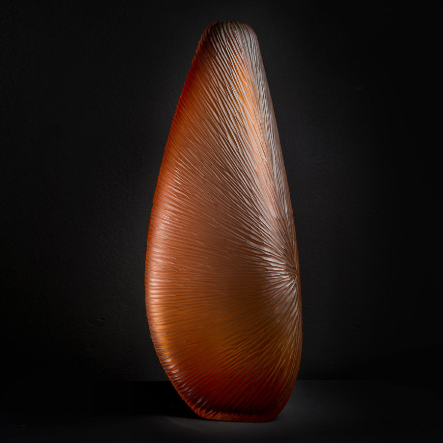 tall abstract glass sculpture with wide base and narrow top looking a bit like a prune