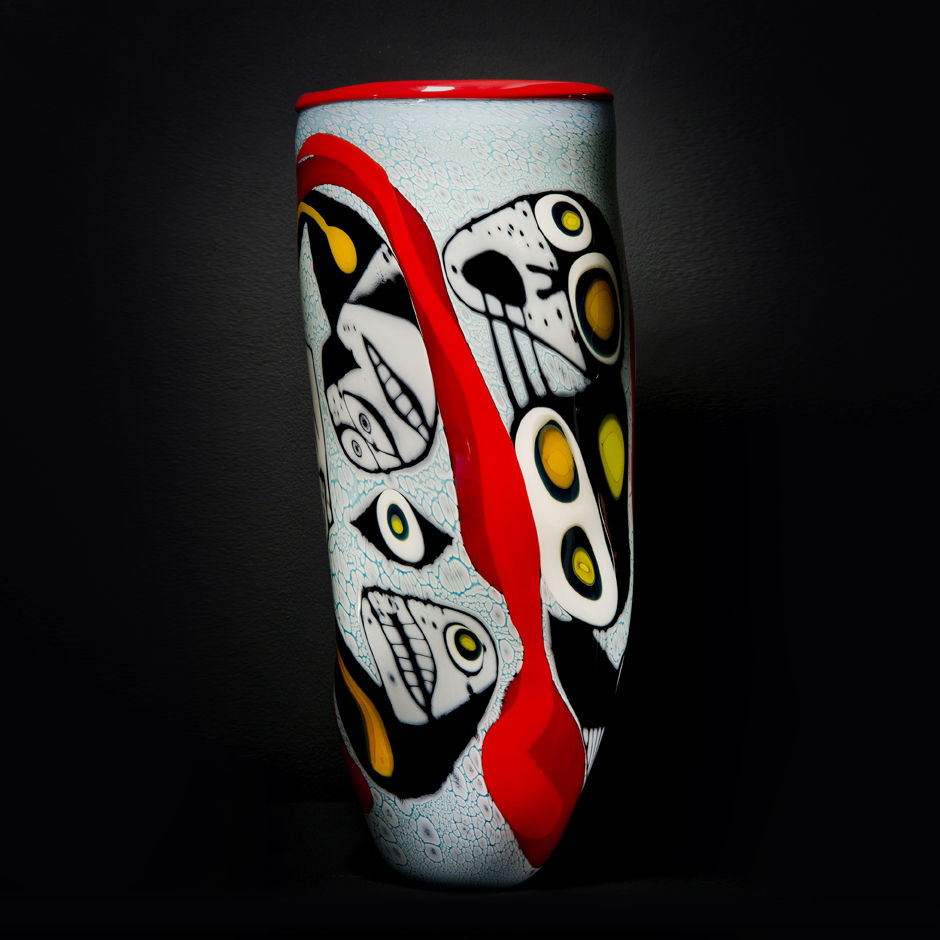 tall art glass vase with abstract faces painted on exterior in white red yellow and black