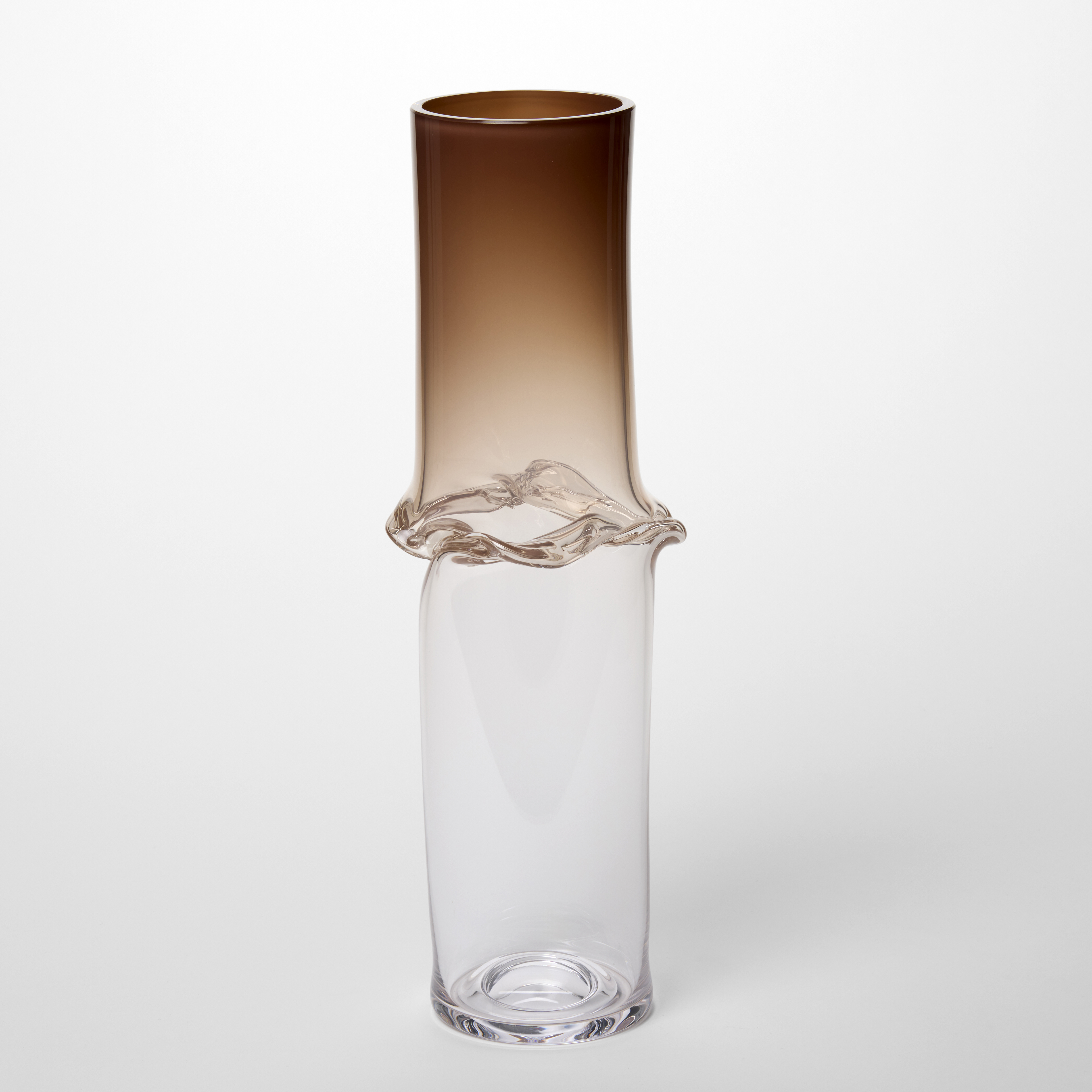 tall transparent thin vessel fading from rich umber brown at the top fading to clear at the bottom with a central creased band hand made from blown glass