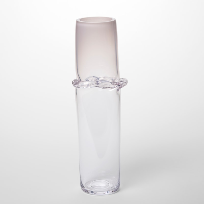 clear cylinder fading from soft opaque pink at the top to clear at the bottom with a creased meridian encircling the form a third of the way down from the top hand made from blown glass