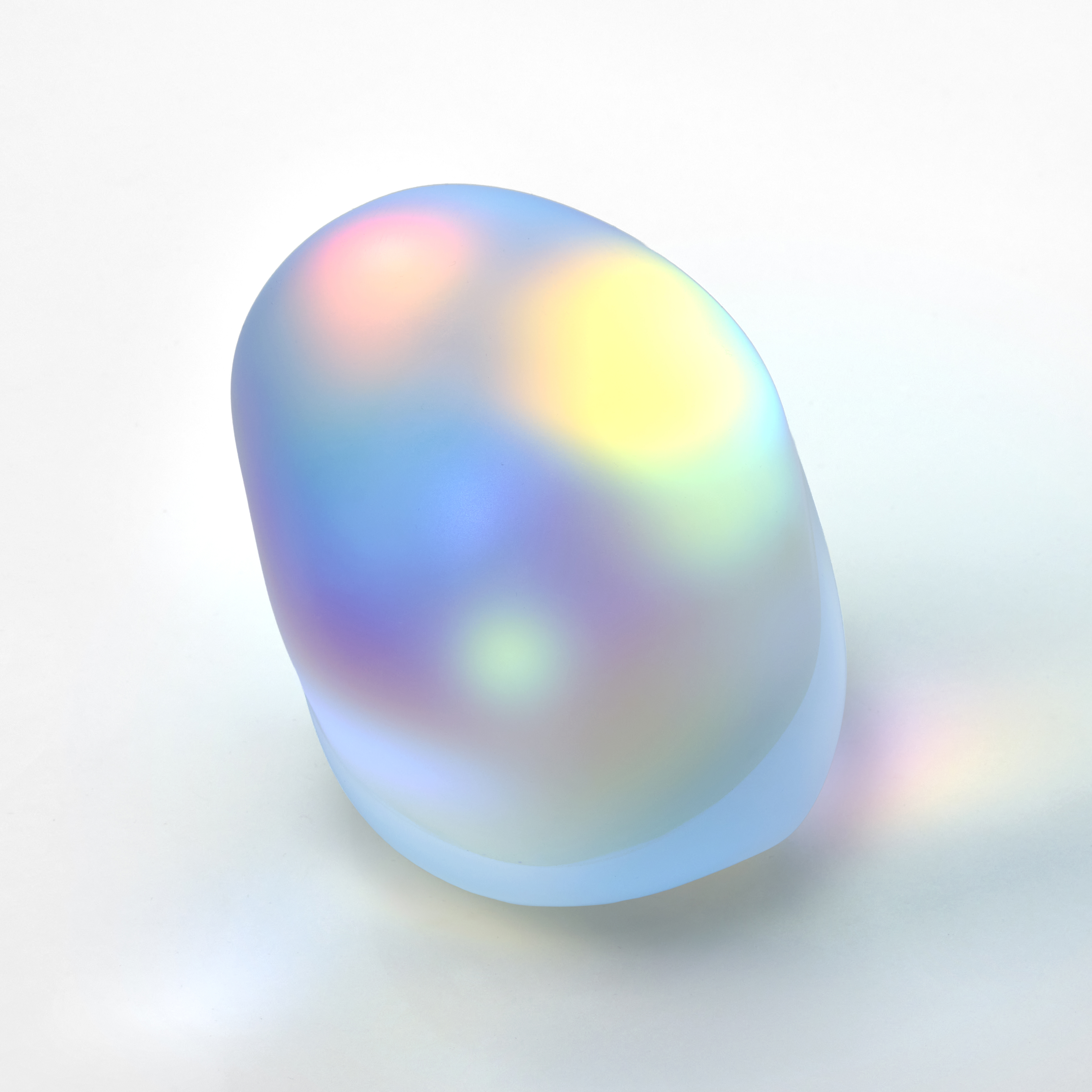 smooth opaque clear pebble with soft iridescent colours glowing from within hand made from glass