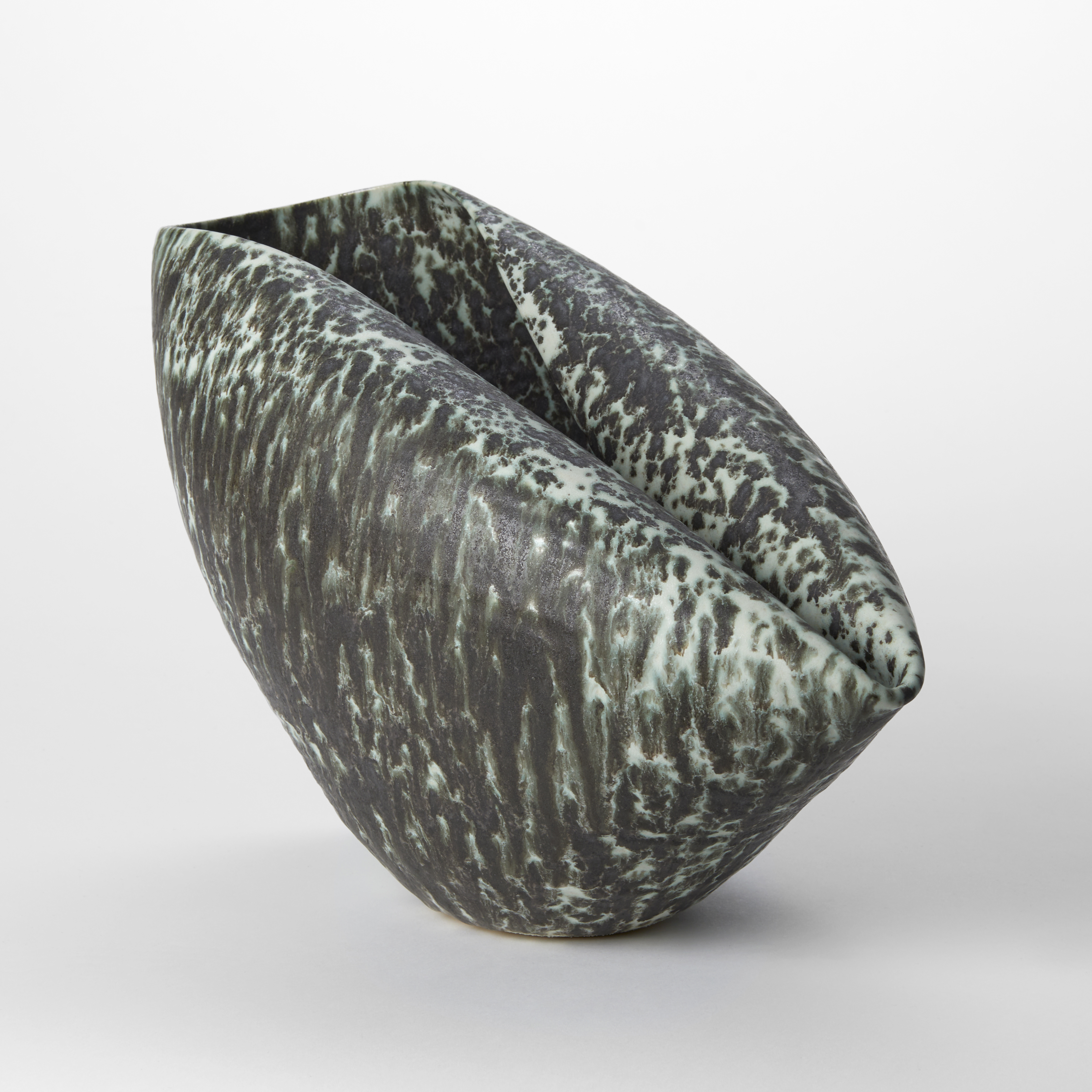dark pewter and soft celadon speckled ceramic centrepiece origami inspired created from a round bowl with one side folder back in on itself creating two elongated rims joined via a rounded crease hand made from clay