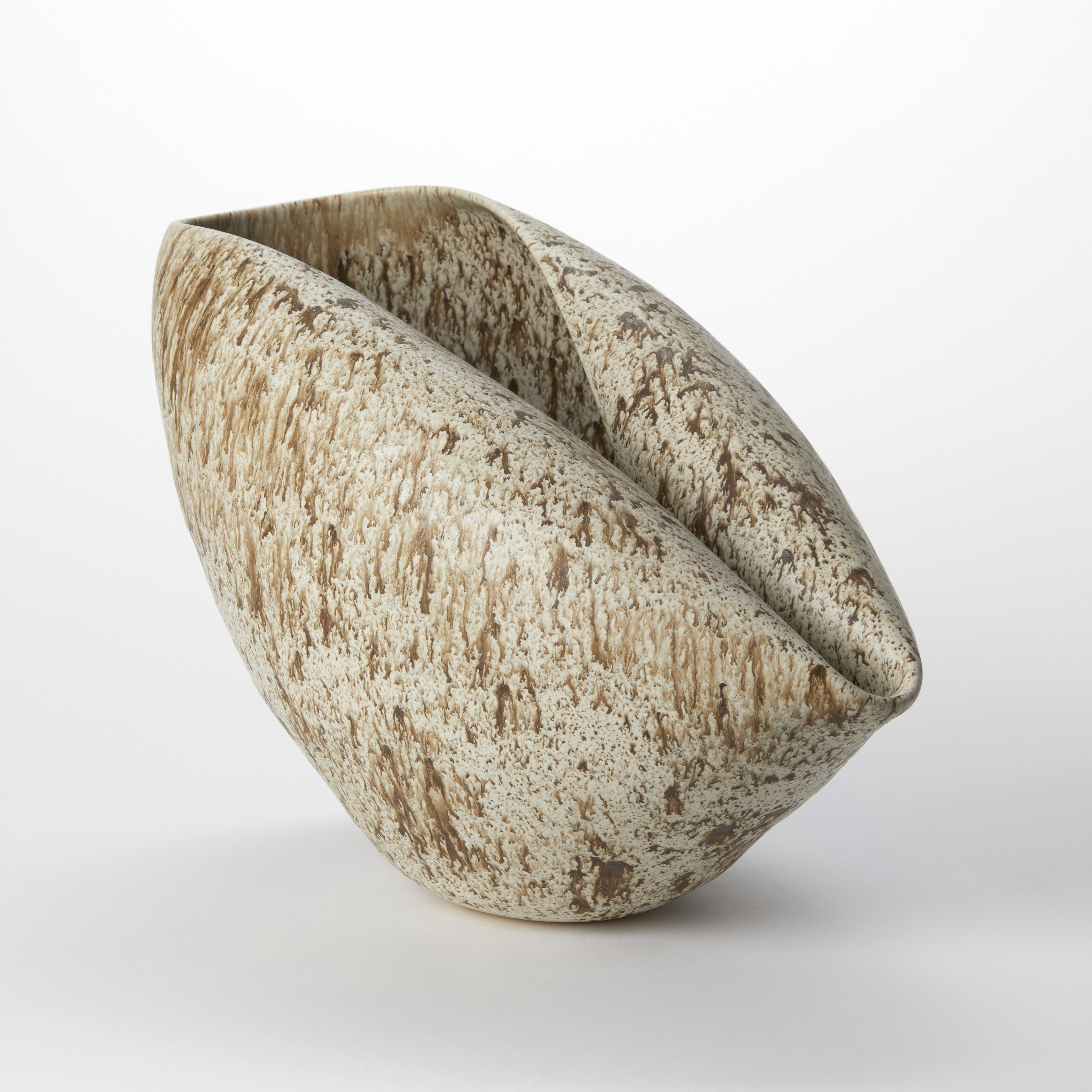 thrown beige round bowl with one side folder in creating a point and two elongated rounded rims with a lichen like brown organic pattern all over the surface hand made from clay