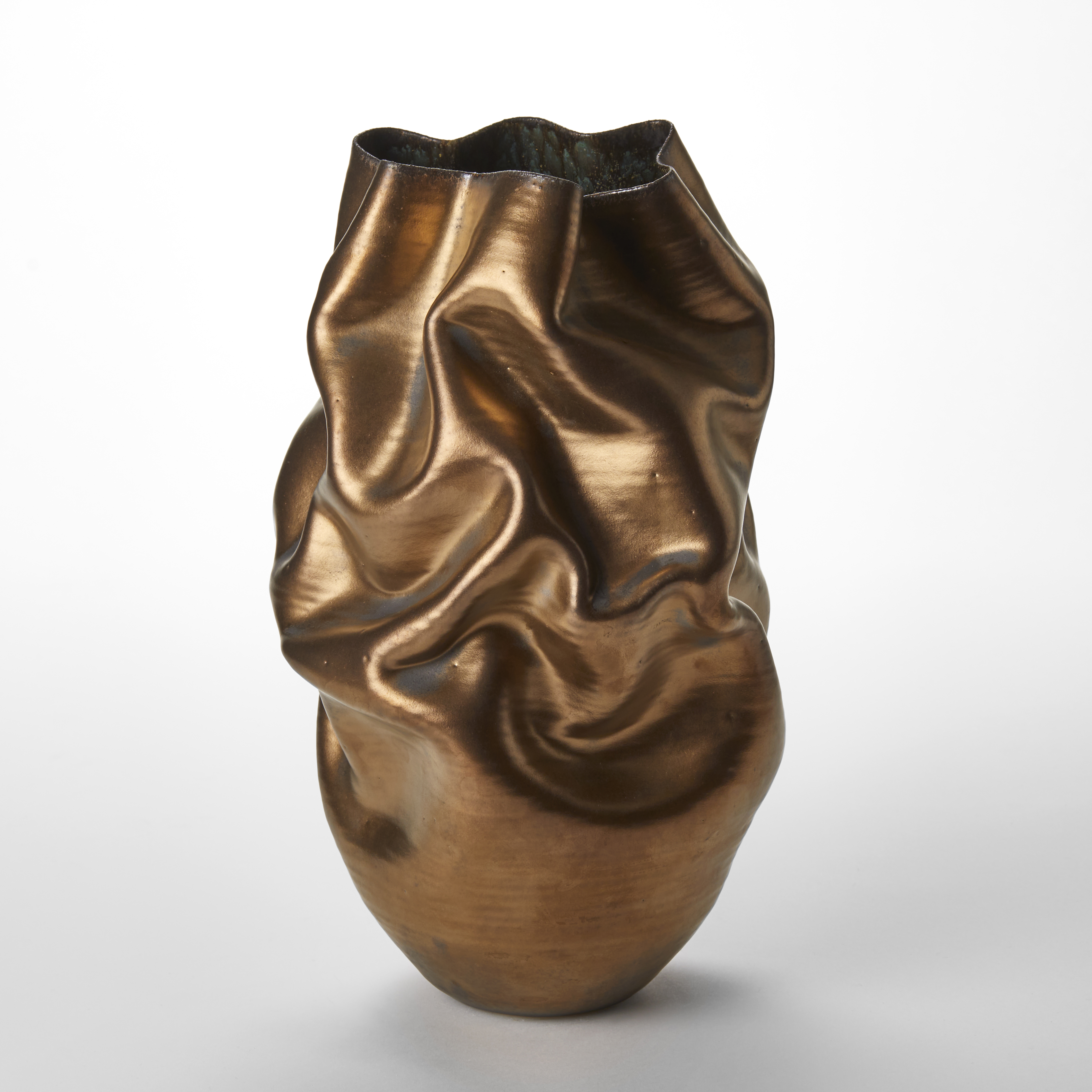 wrinkled and creased standing vessel with undulating top edge with a burnished gold finish on the exterior hand made from clay