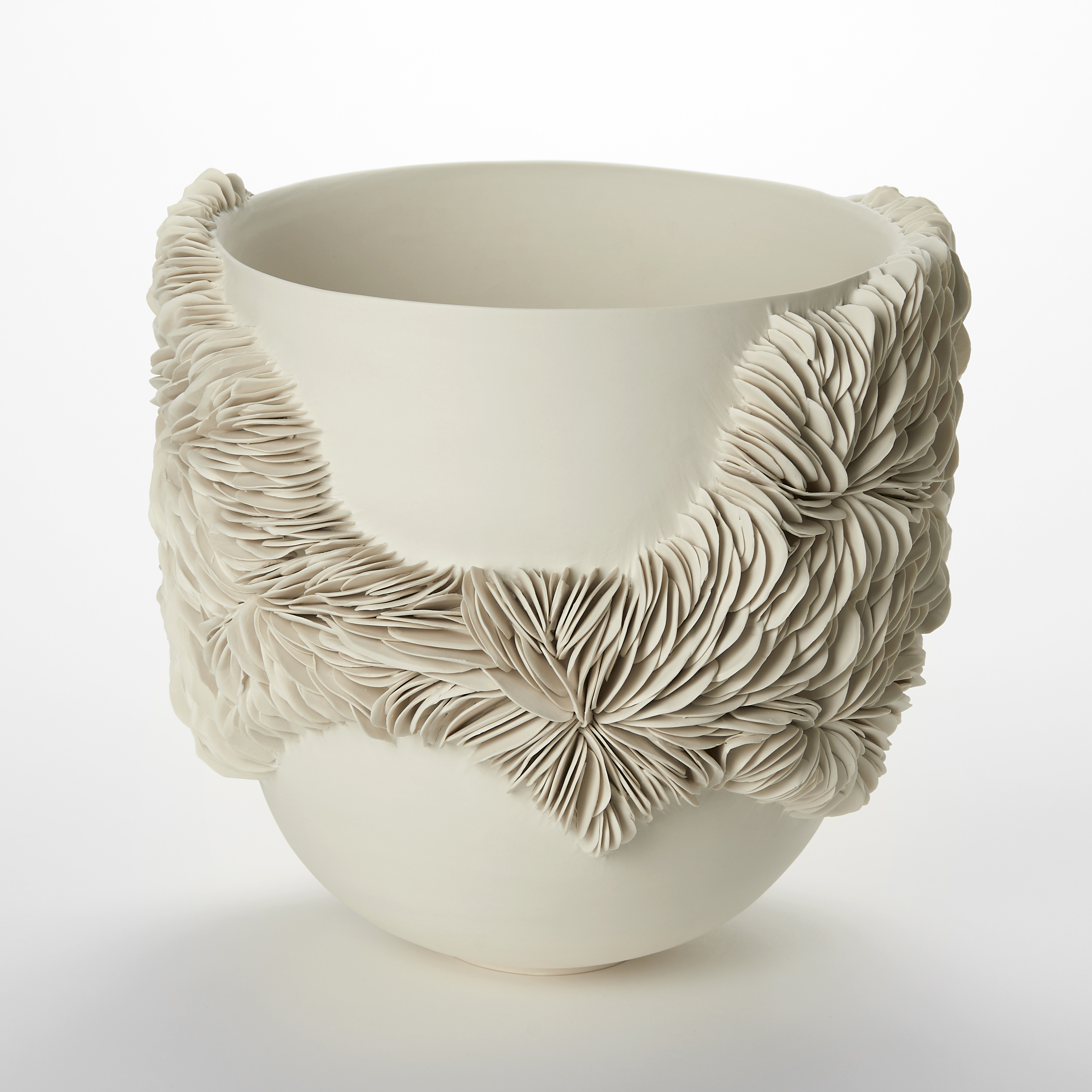 round bowl with high parallel sides in an off white cream alabaster colour with a protruding irregular width band of small shards stacked one beside the other following the full circumference hand made from porcelain