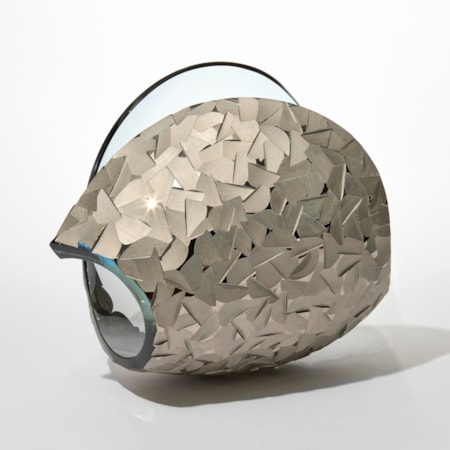 transparent curled simplified shell form in soft ice blue with one side covered in angled facets in matt platinum silver hand made and blown from glass and silver lustre