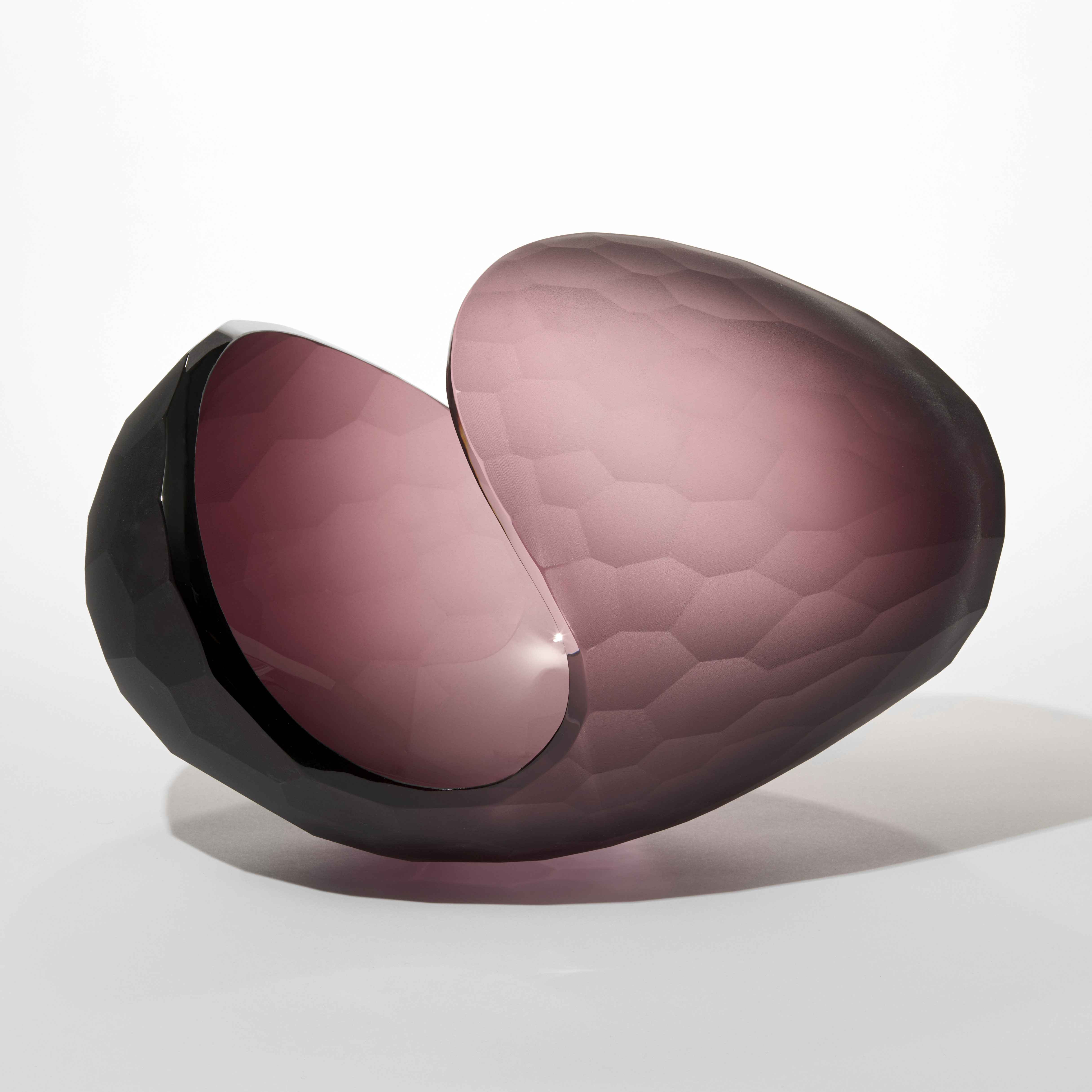 prone ovoid shape in soft matt aubergine colour with the outer surface with a large incised repeat cut scalloped pattern hand blown from glass