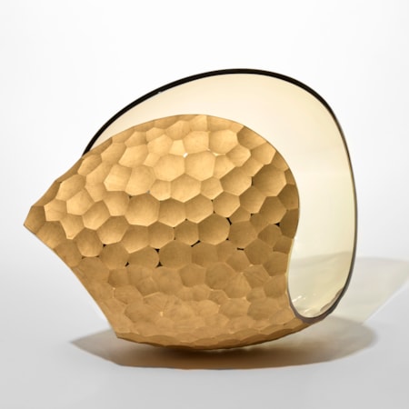 curled shell like form in transparent soft amber with one side covered in repeat cut scalloped recesses hand blown from glass with a twenty three carat gold finish