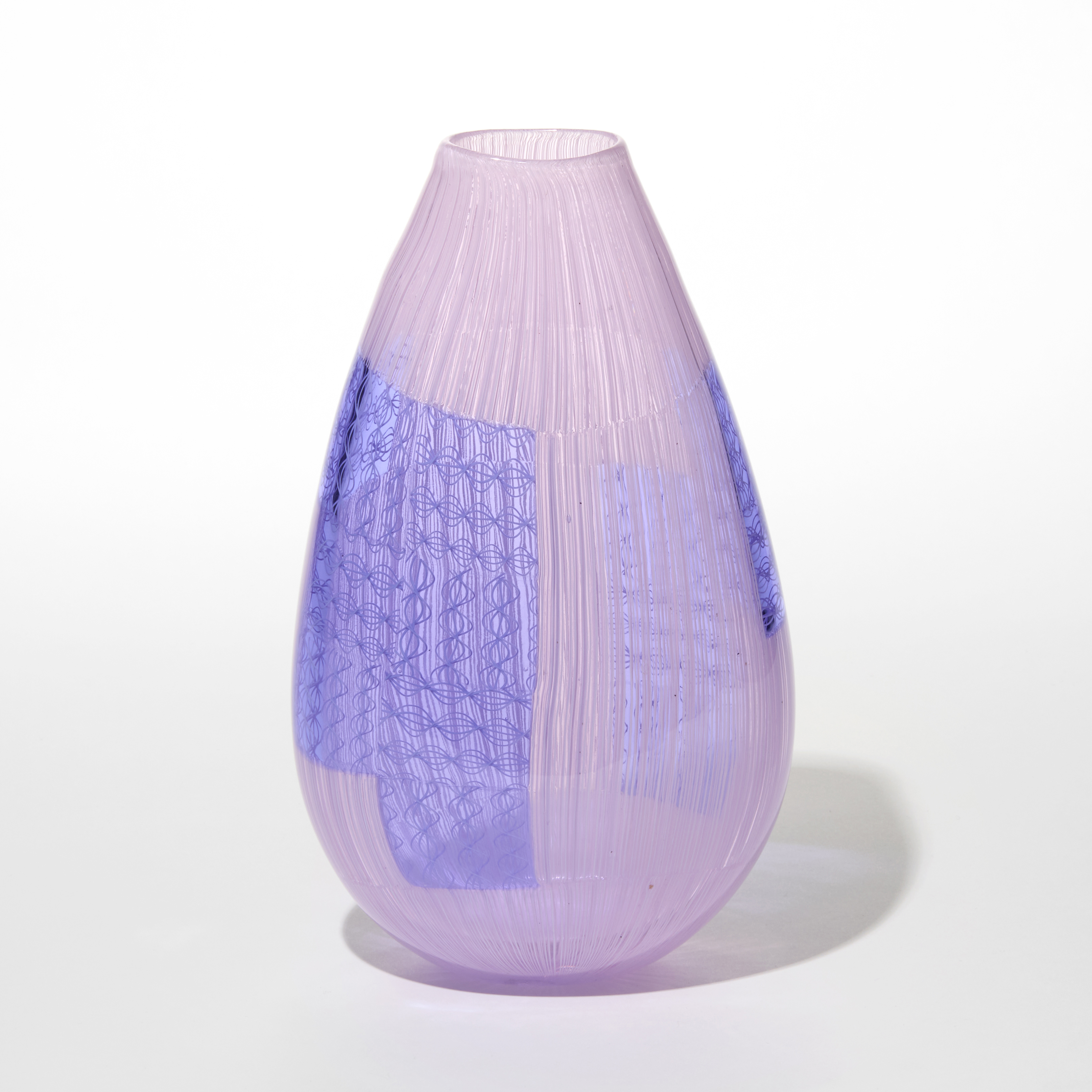 handblown teardrop shaped glass vase with a smooth translucent pink surface and vertical striations running through it and embedded rectangular and curved patches of deep lavender blue lilac resembling woven or grid like patterns creating a layered effect hand blown from glass