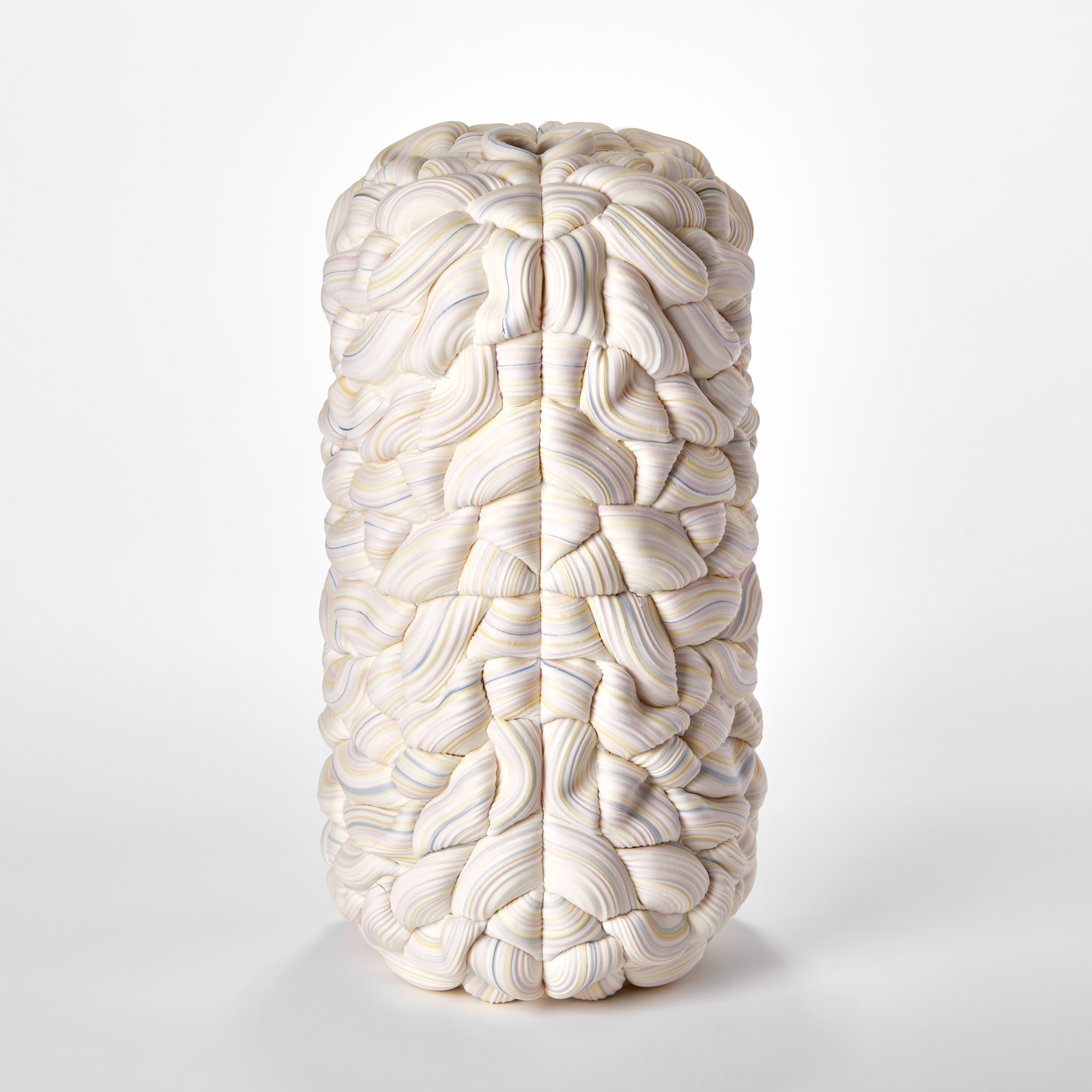 stacked sculptural vessel made up of interwoven sugary ridged rings in white with bands of soft pastel colours with front seam and the two halves mirroring each other