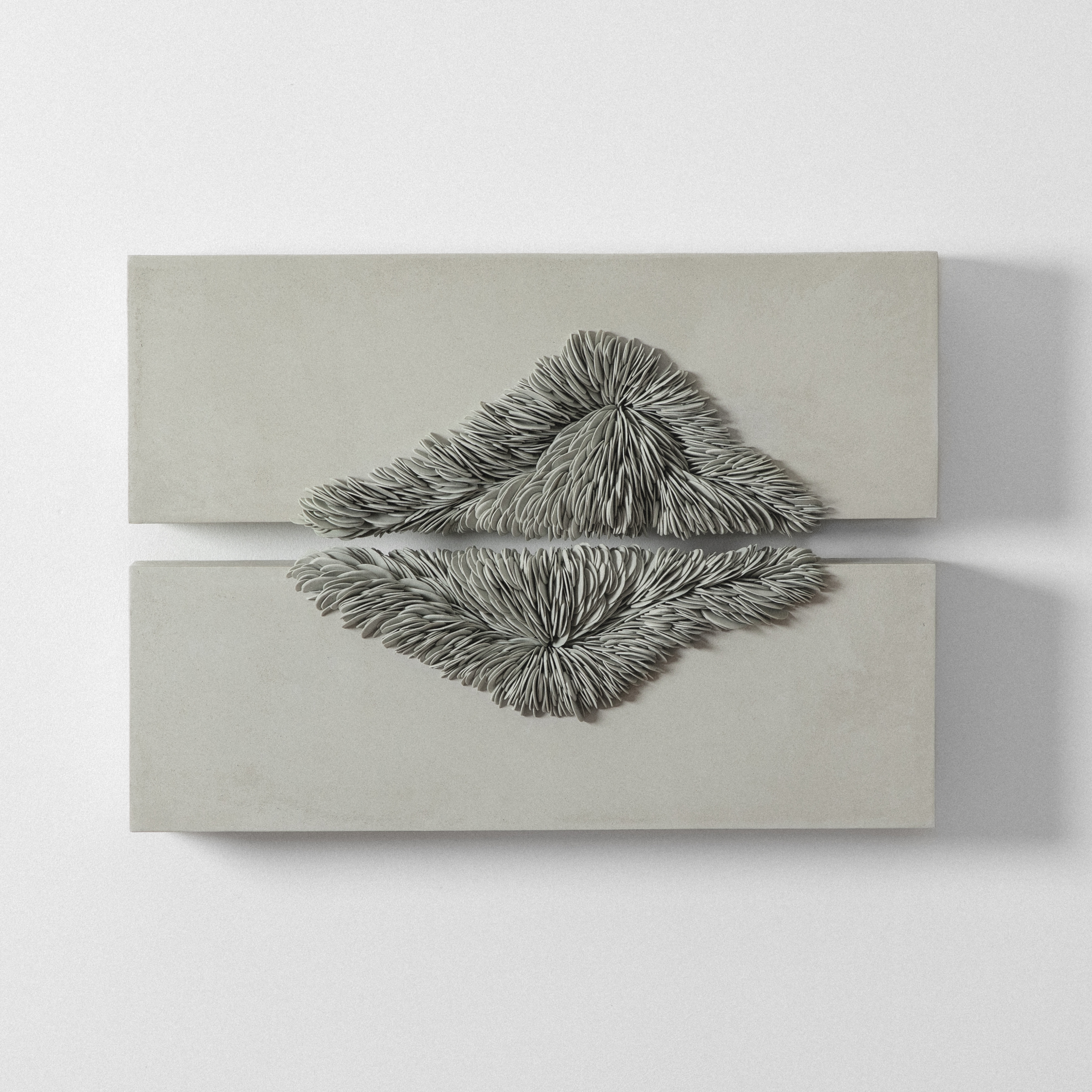 wall hanging artwork consisting of two horizontal chunky rectangles in soft green with the central areas of both featuring an organic mass of small interlocking shards with the appearance as if growing outwards hand made from porcelain and tadelakt plaster