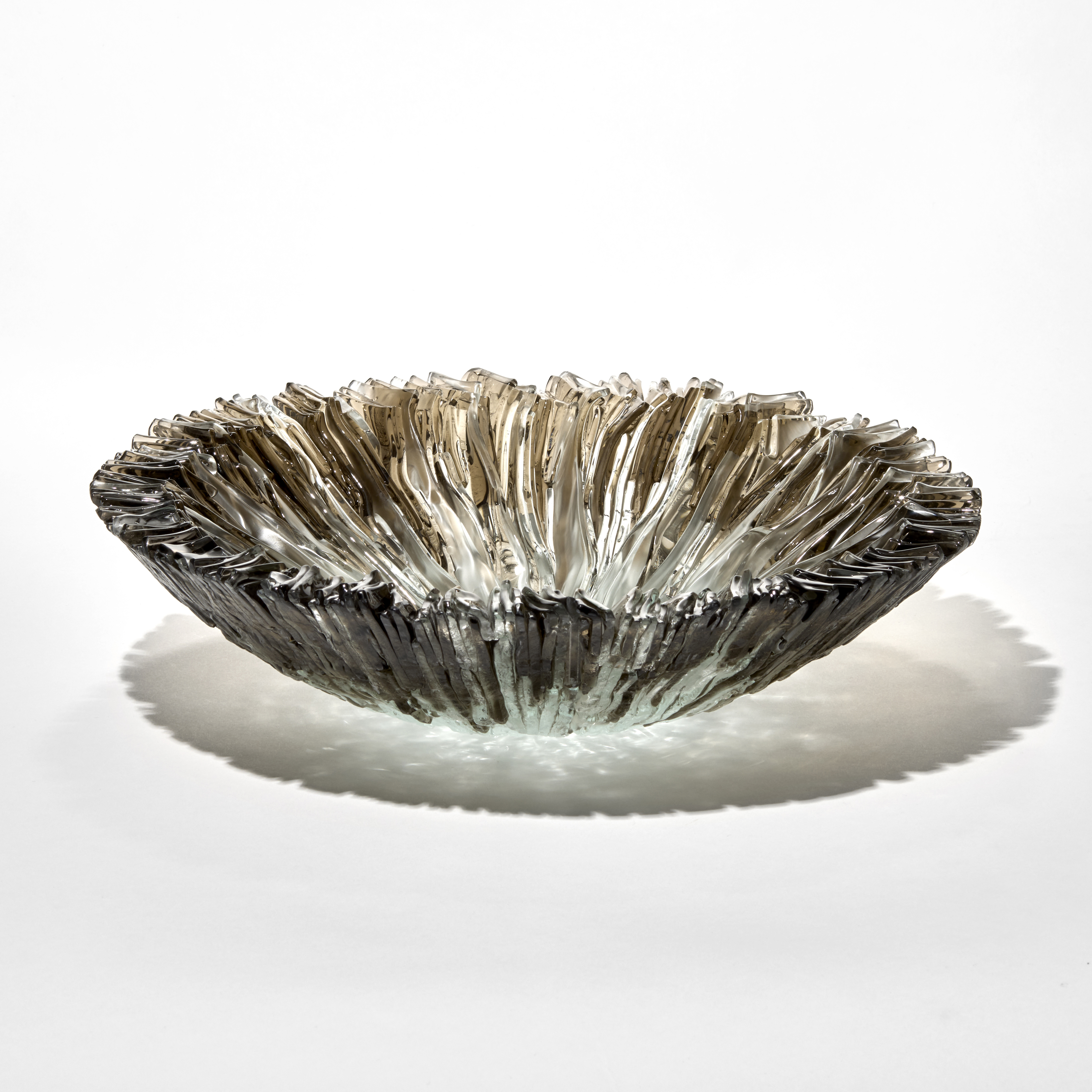 low round textured centrepiece and bowl in translucent bronze brown fading to the centre in light jade with the top surface covered in soft wavy ridges hand made from fused glass