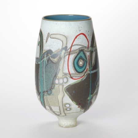 round teardrop shaped vase with wide opening and small foot in opaque mottled white covered in abstract linear and circular patterns in chocolate teal beige and red with a shiny interior in duck egg blue with a thin olive green rim hand blown and sculpted from glass