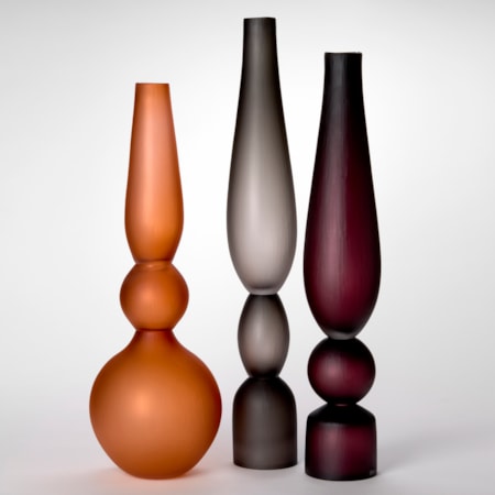 trio of opaque architectural tall standing vases each made of three stacked components and shapes and a soft satin surface finish with one in turquoise one in grey and one in sienna made from hand blown and cut glass