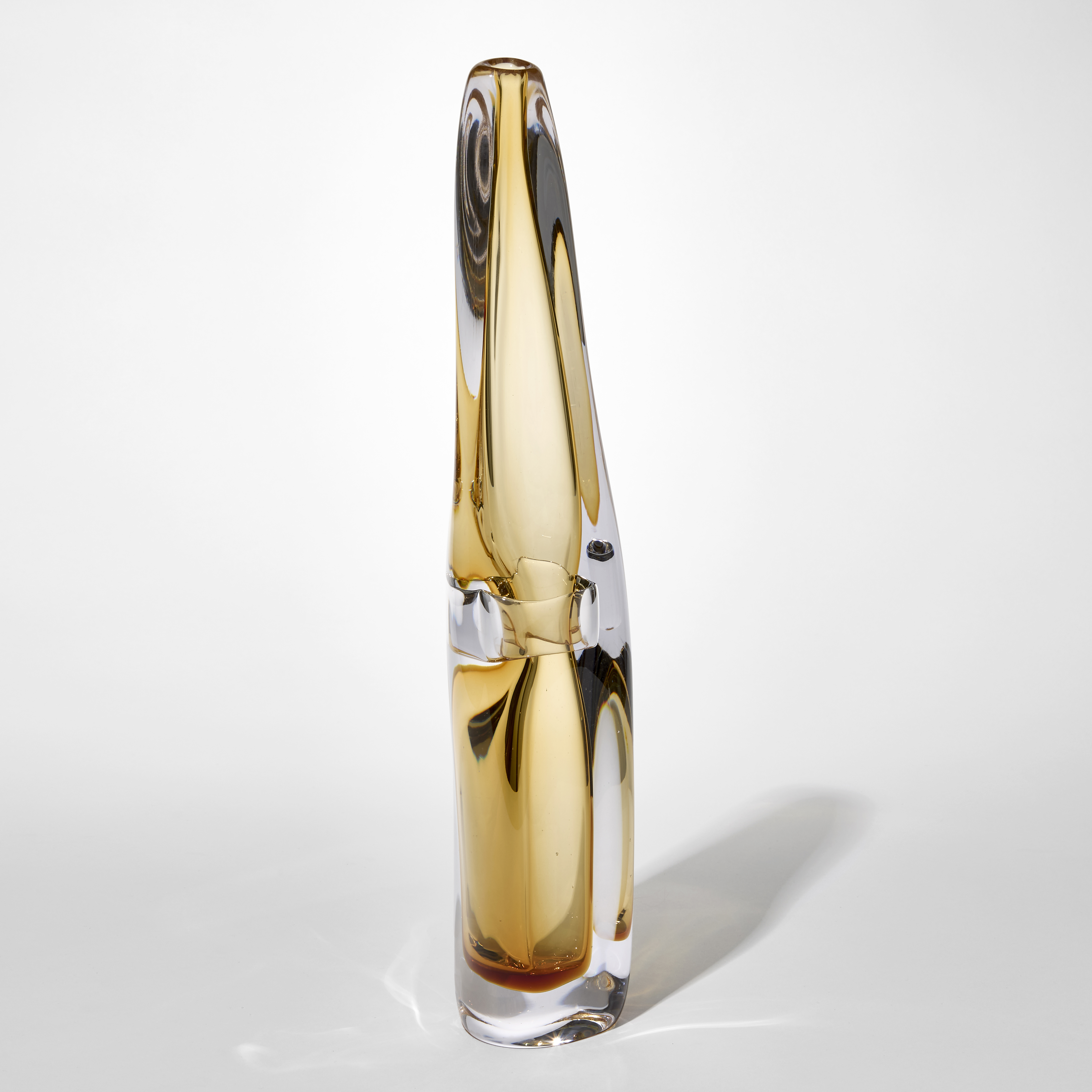 transparent tall fluid vase with thick clear outer layer and inner trapped layer in soft warm yellow with a pinched in section half way up hand blown from glass